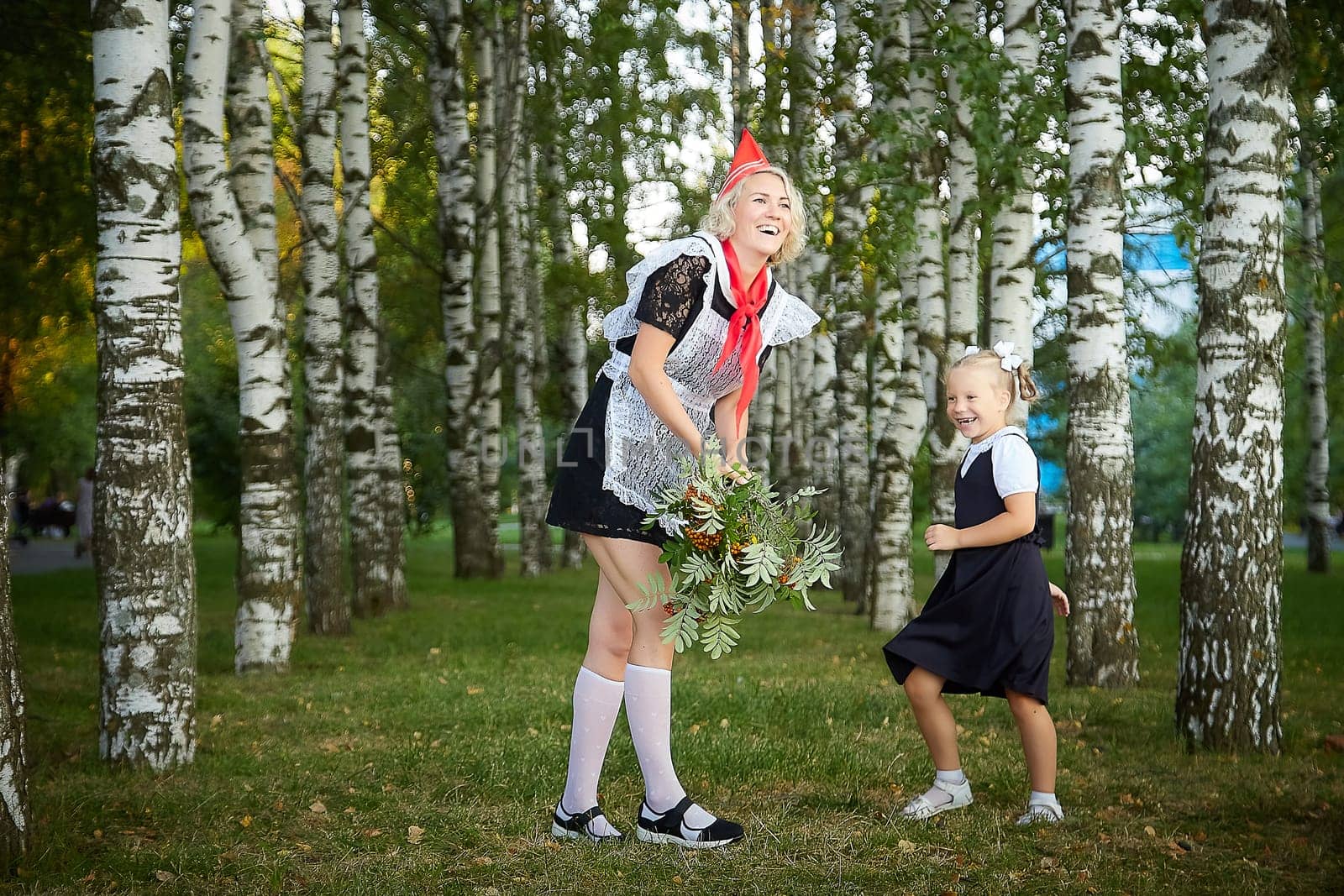 Young and adult schoolgirl on September 1, mother and daughter having fun and joy. Generations of schoolchildren of USSR and Russia. Female pioneer in red tie and October girl in modern uniform