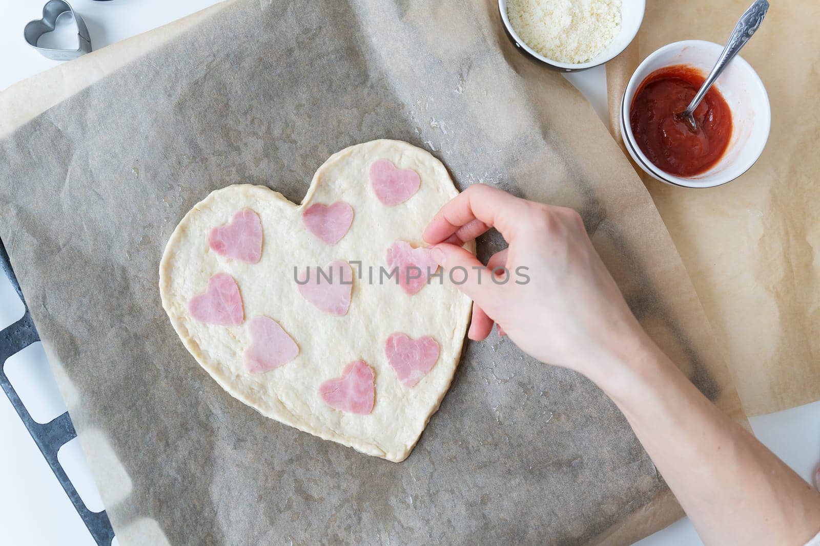 Heart shaped pizza dough, chef lays heart shaped sausage. Italian pizza, heart shaped pizza. by sfinks