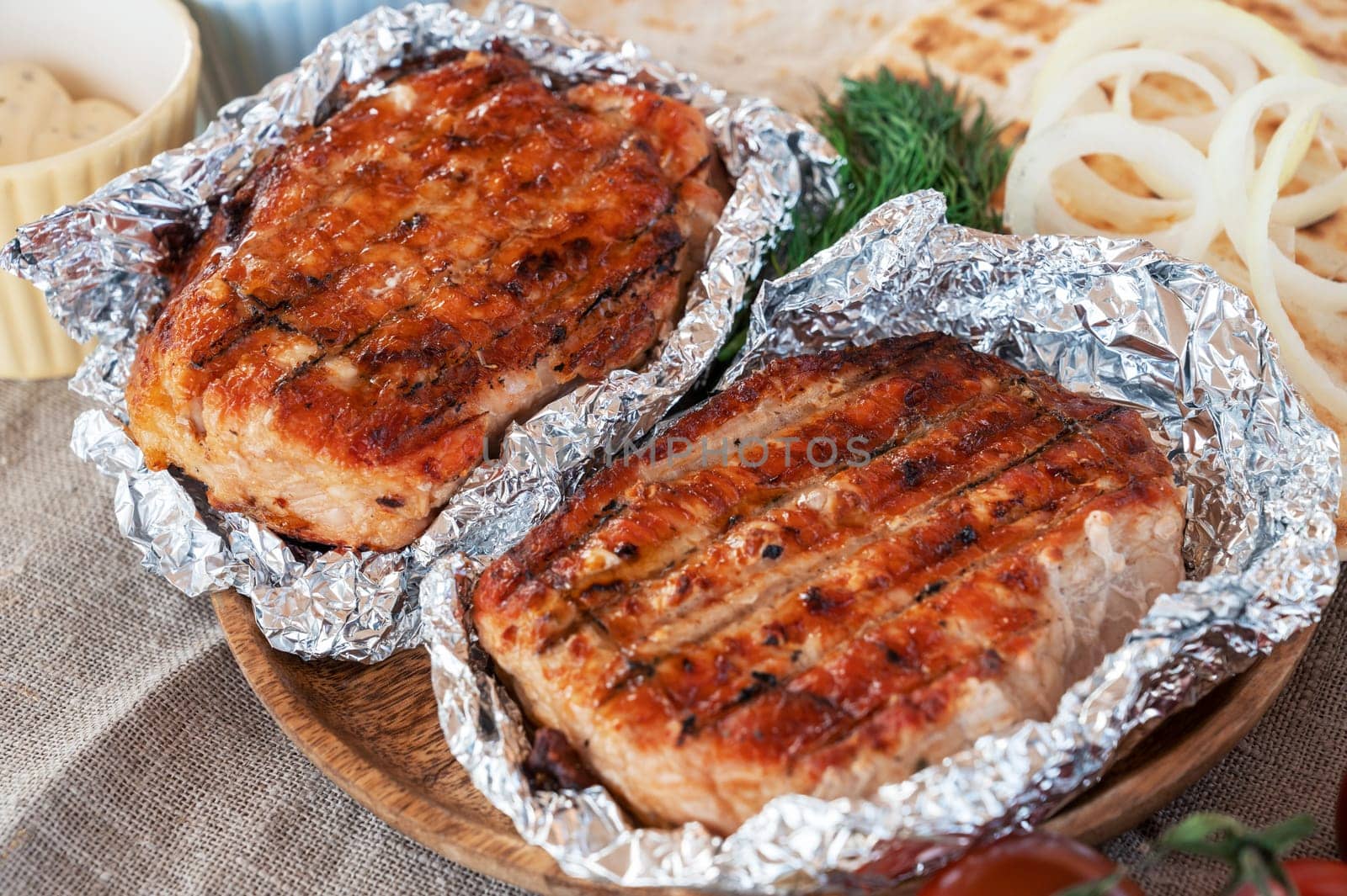 Grilled pork meat in foil with flapjack and vegetables. Summer rest concept