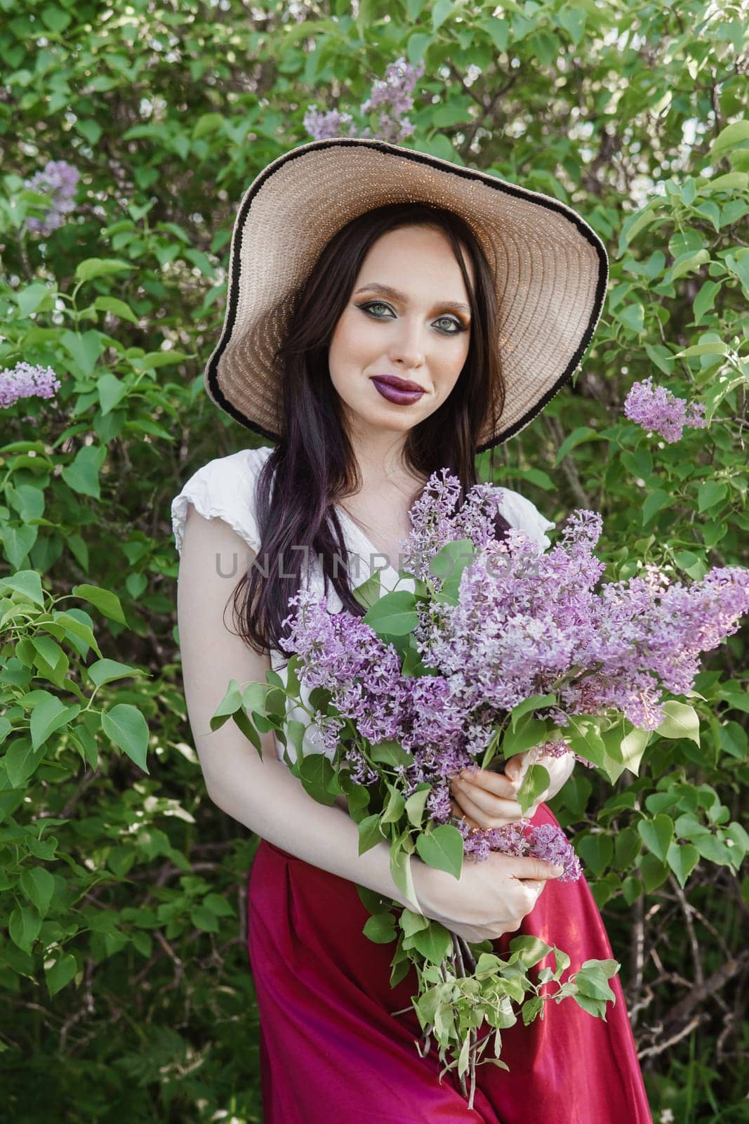 A fashionable girl with dark hair, a spring portrait in lilac tones in summer. Bright professional makeup