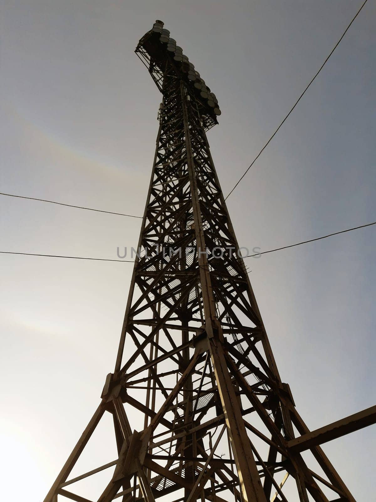 Metal tower with round spotlights for lighting a sports stadium in the city.Metal column for lighting.