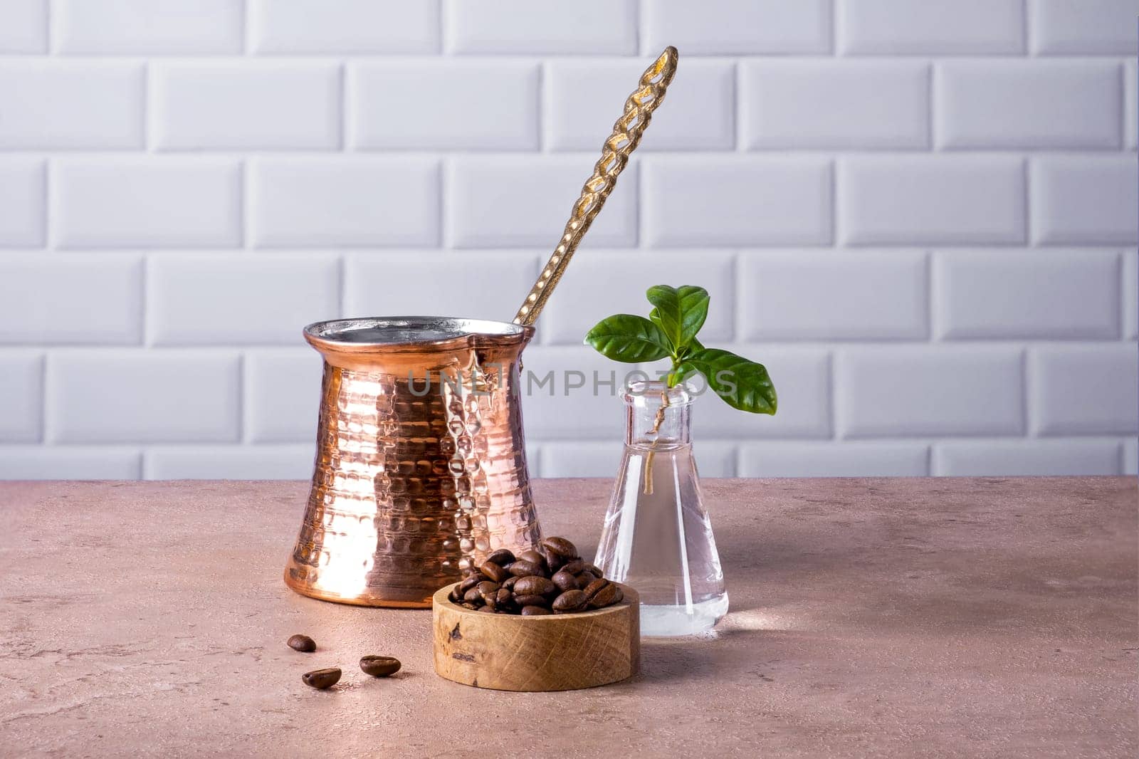 Composition of a traditional Turkish coffee pot cezve, coffee beans and a branch of a coffee tree. Selective focus.