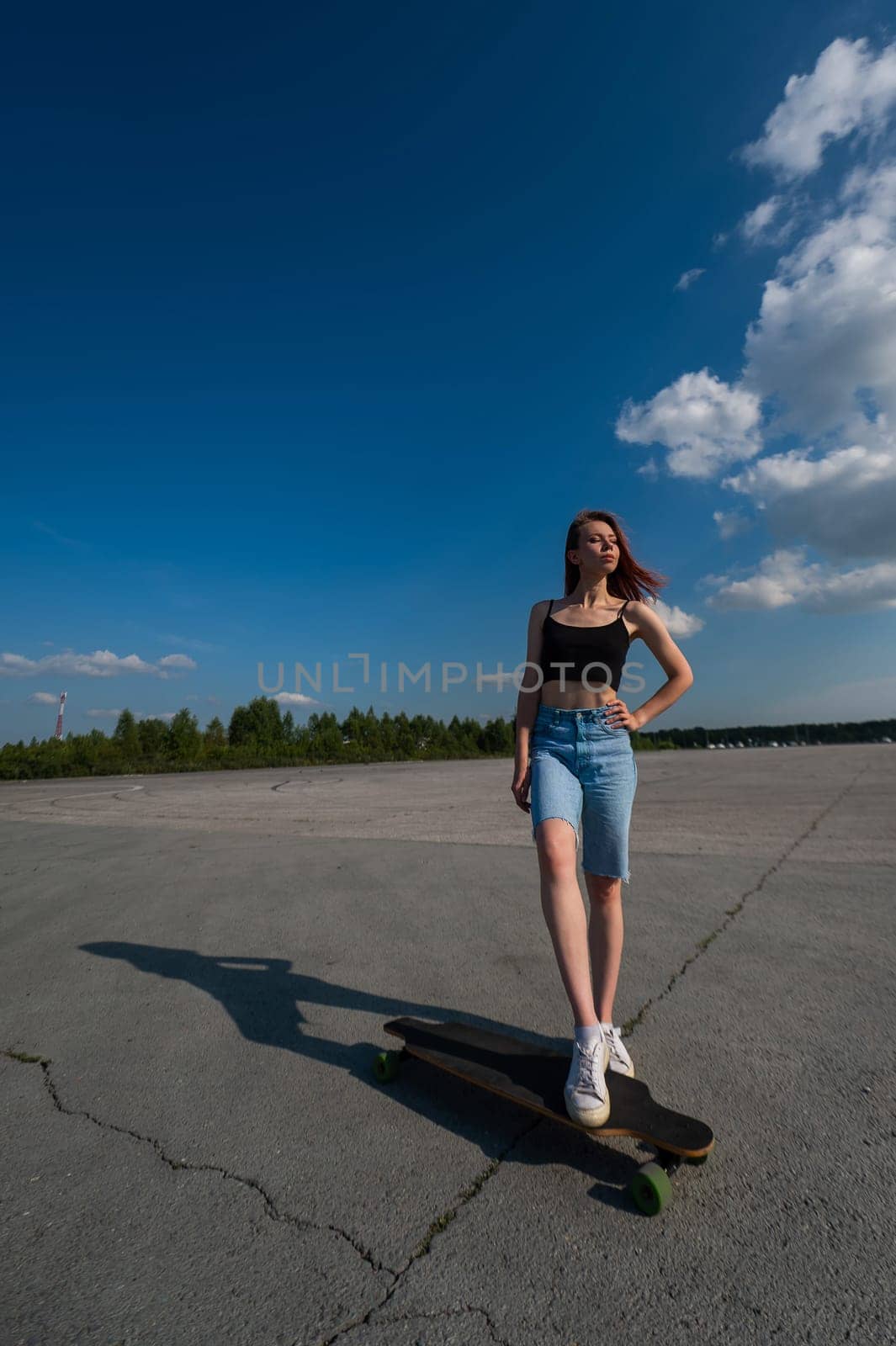 Young caucasian woman riding a longboard outdoors