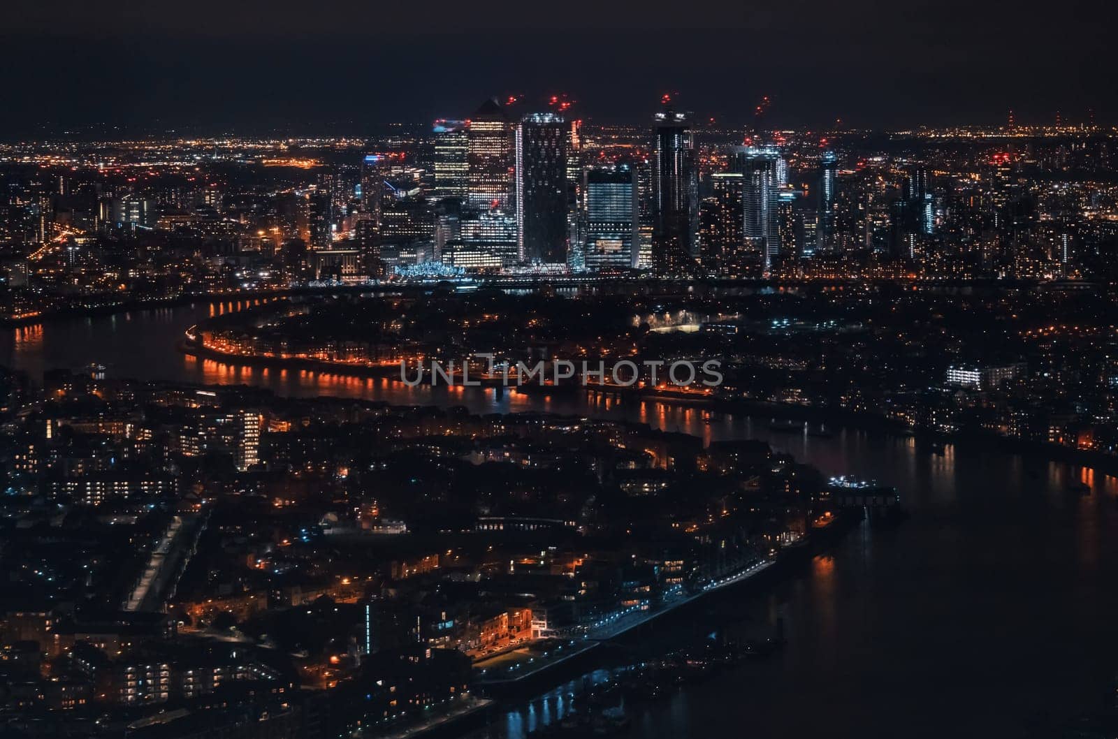 Aerial view of London at night, north eastern part, Isle of Dogs on river Thames, with Canary Wharf financial district.