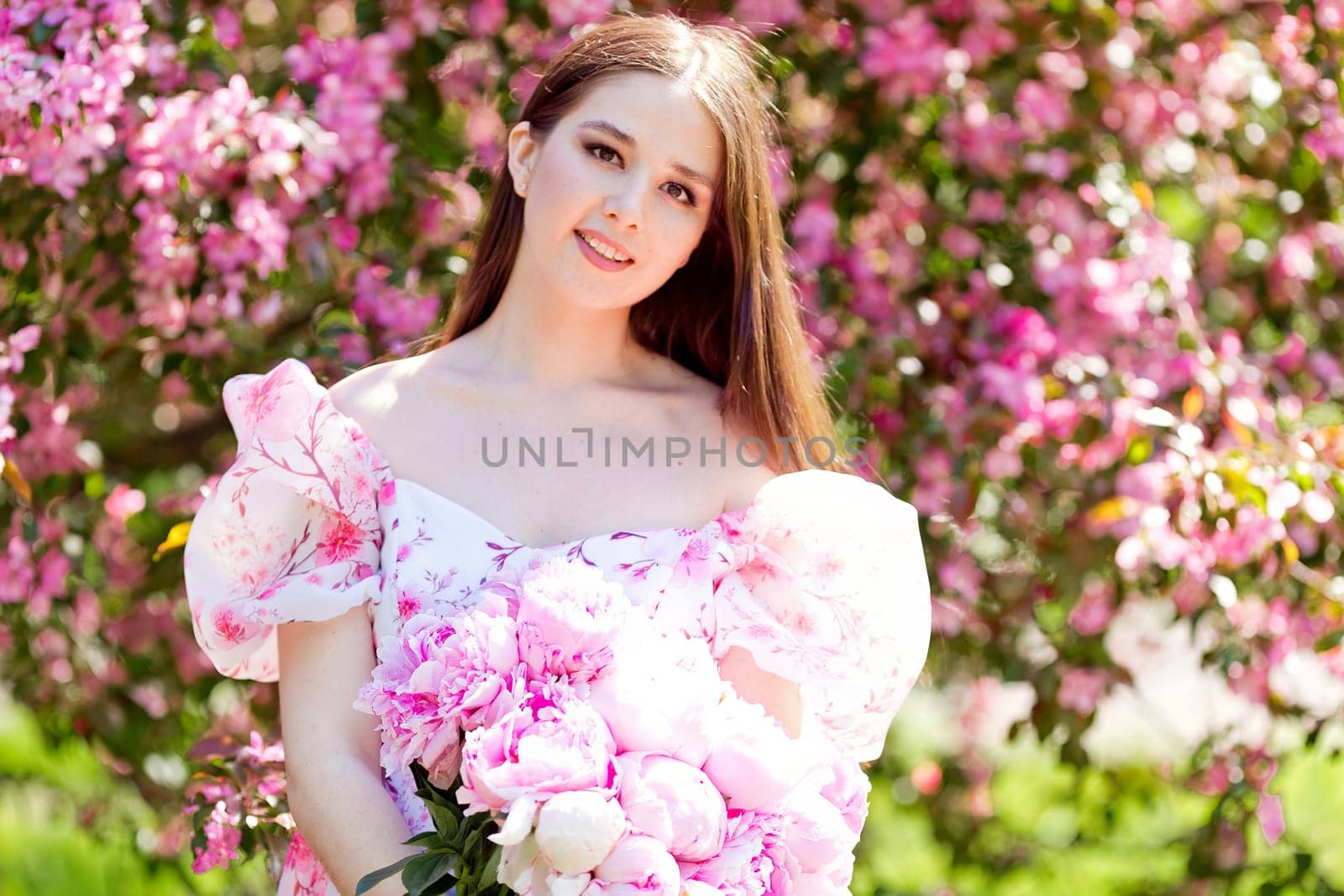 A beautiful girl holding a large bouquet of pink peonies by Zakharova
