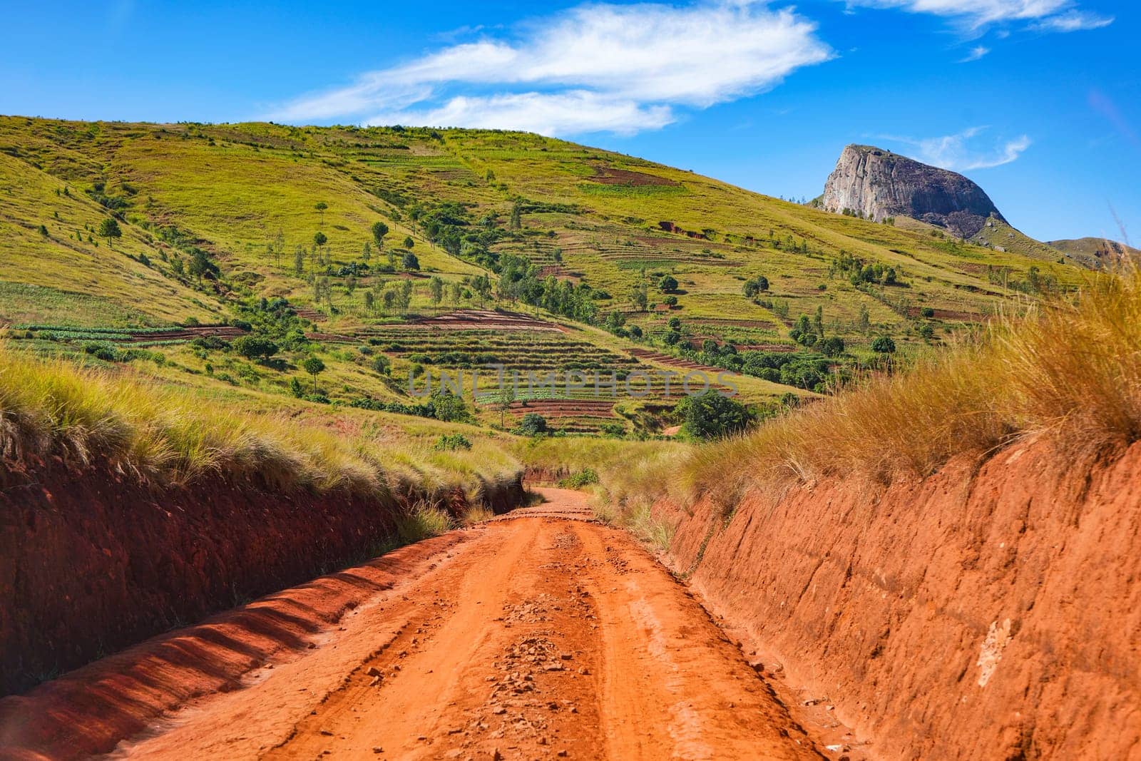 Red dust and mud road in poor condition with ridges formed after rain. Routes to Andringitra national park are bad during wet season in region near Ambalavao, Madagascar.
