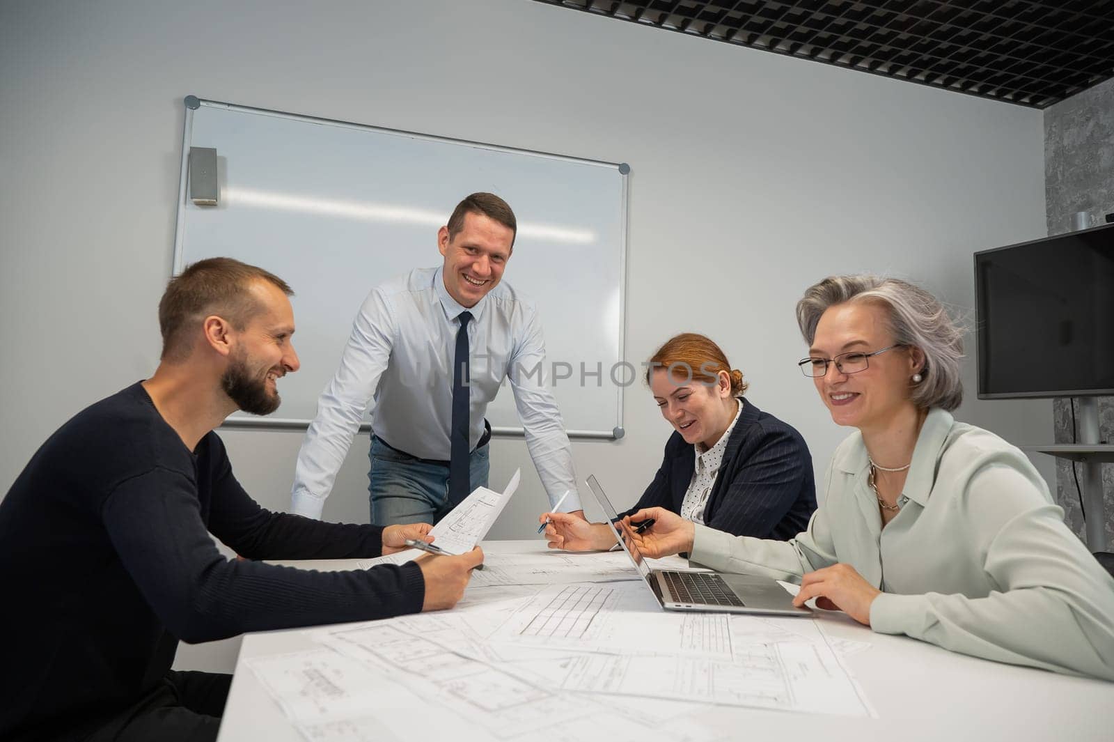 Caucasian man leading a presentation to colleagues at a white board