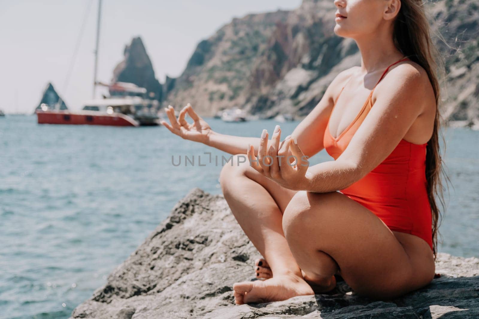 Woman sea yoga. Back view of free calm happy satisfied woman with long hair standing on top rock with yoga position against of sky by the sea. Healthy lifestyle outdoors in nature, fitness concept.