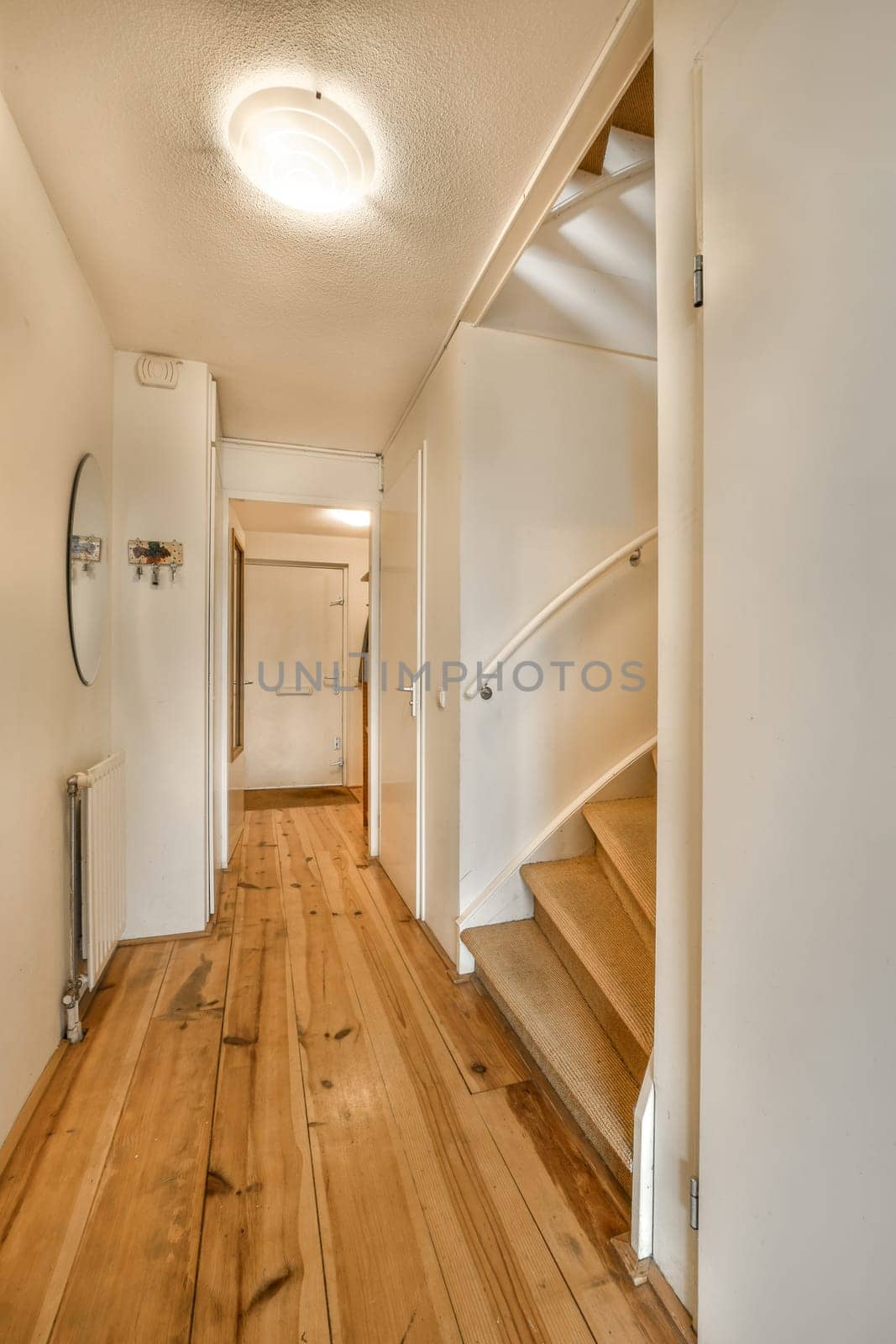 an empty room with wood flooring and white walls on either side of the room there is a staircase leading up to the second
