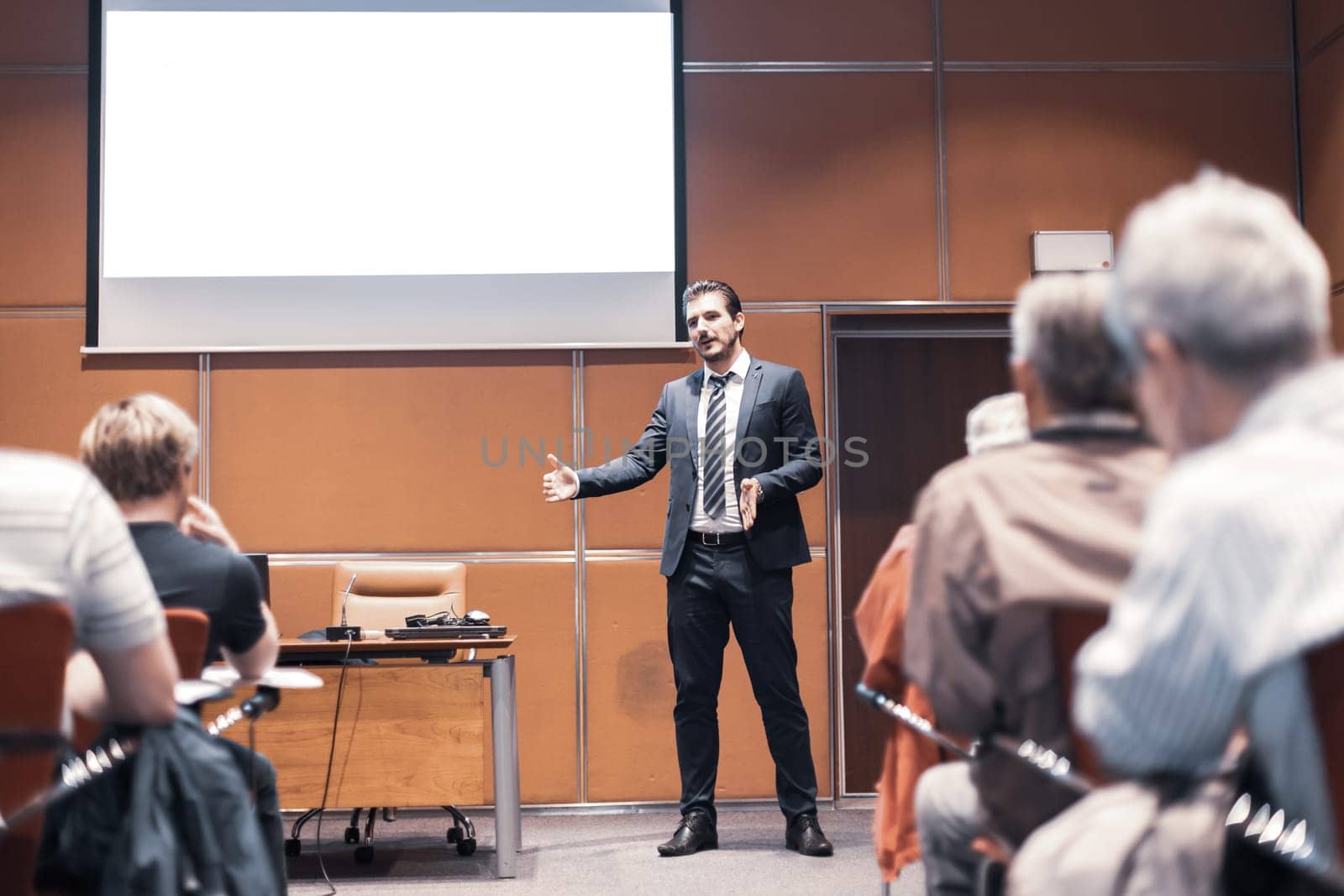 Speaker Giving a Talk at Business Meeting. Audience in the conference hall. Business and Entrepreneurship. Copy space on white board.