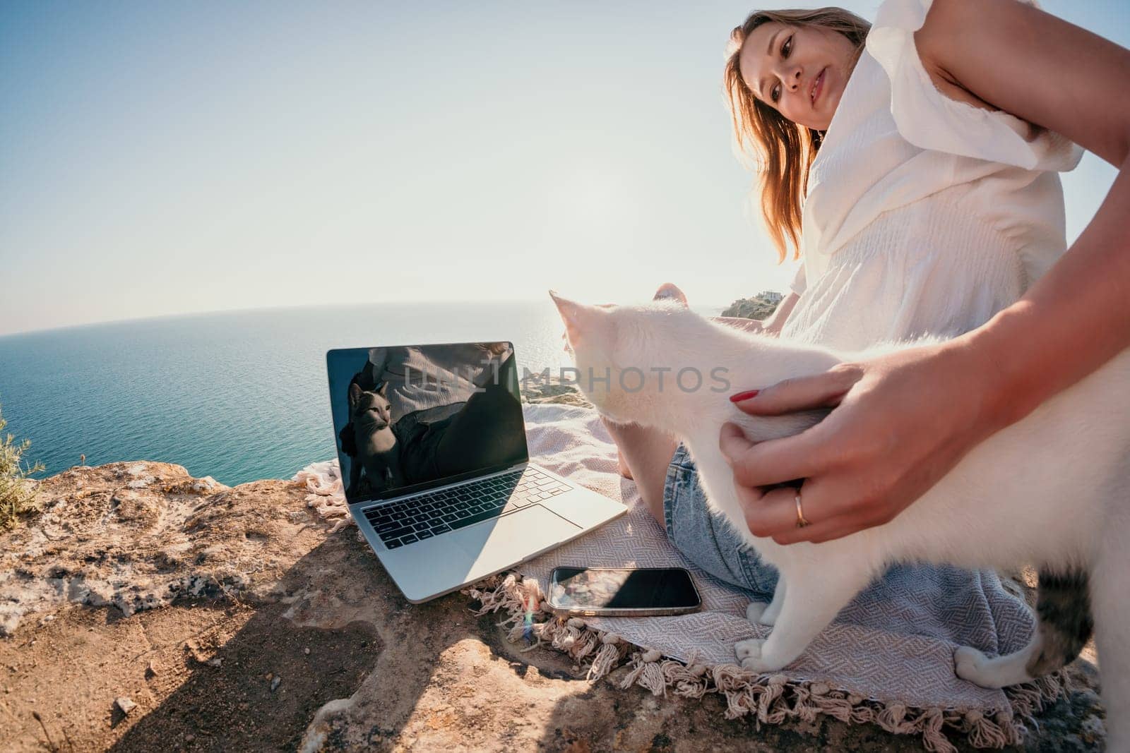 Woman sea laptop. Business woman in yellow hat working on laptop by sea. Close up on hands of pretty lady typing on computer outdoors summer day. Freelance, digital nomad, travel and holidays concept.