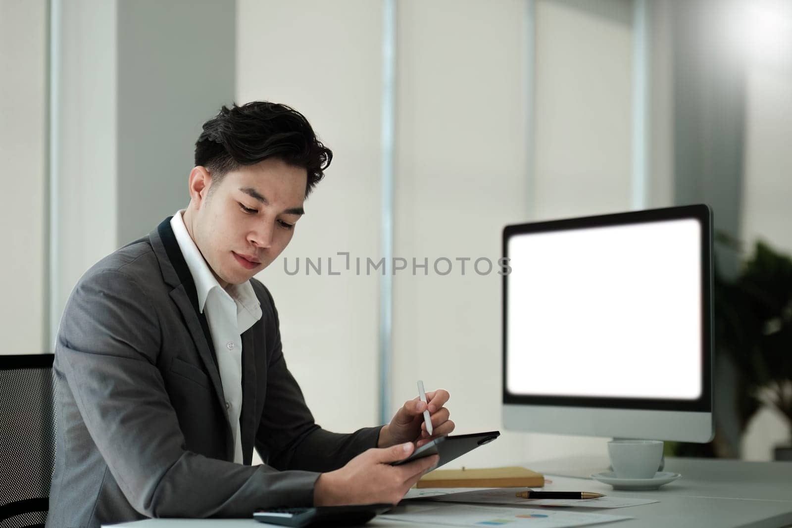 Business man working analyst of work on lnotebook pc while sitting at wooden table. Business man analyze stock report on notebook pc screen..