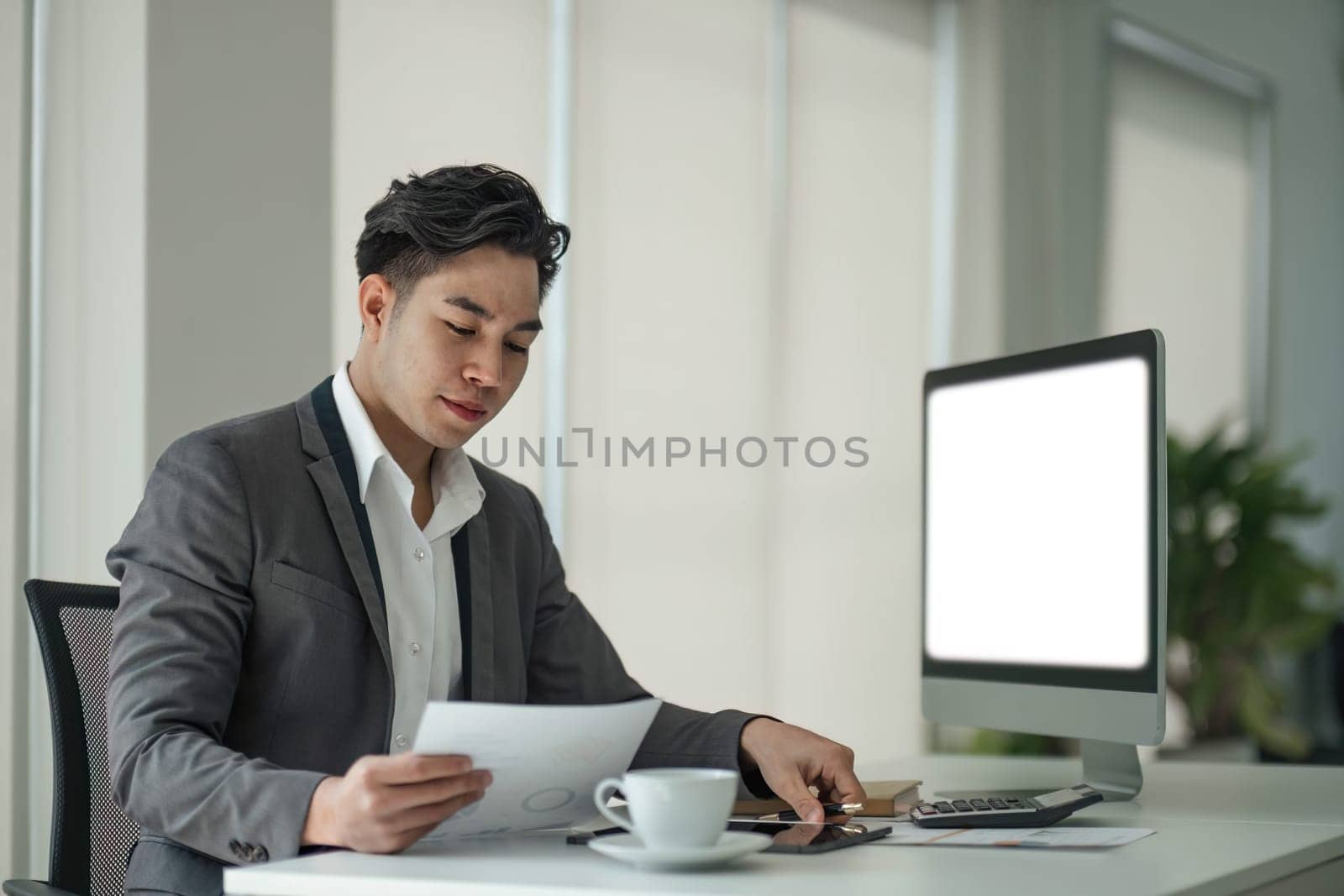Business man working analyst of work on lnotebook pc while sitting at wooden table. Business man analyze stock report on notebook pc screen..