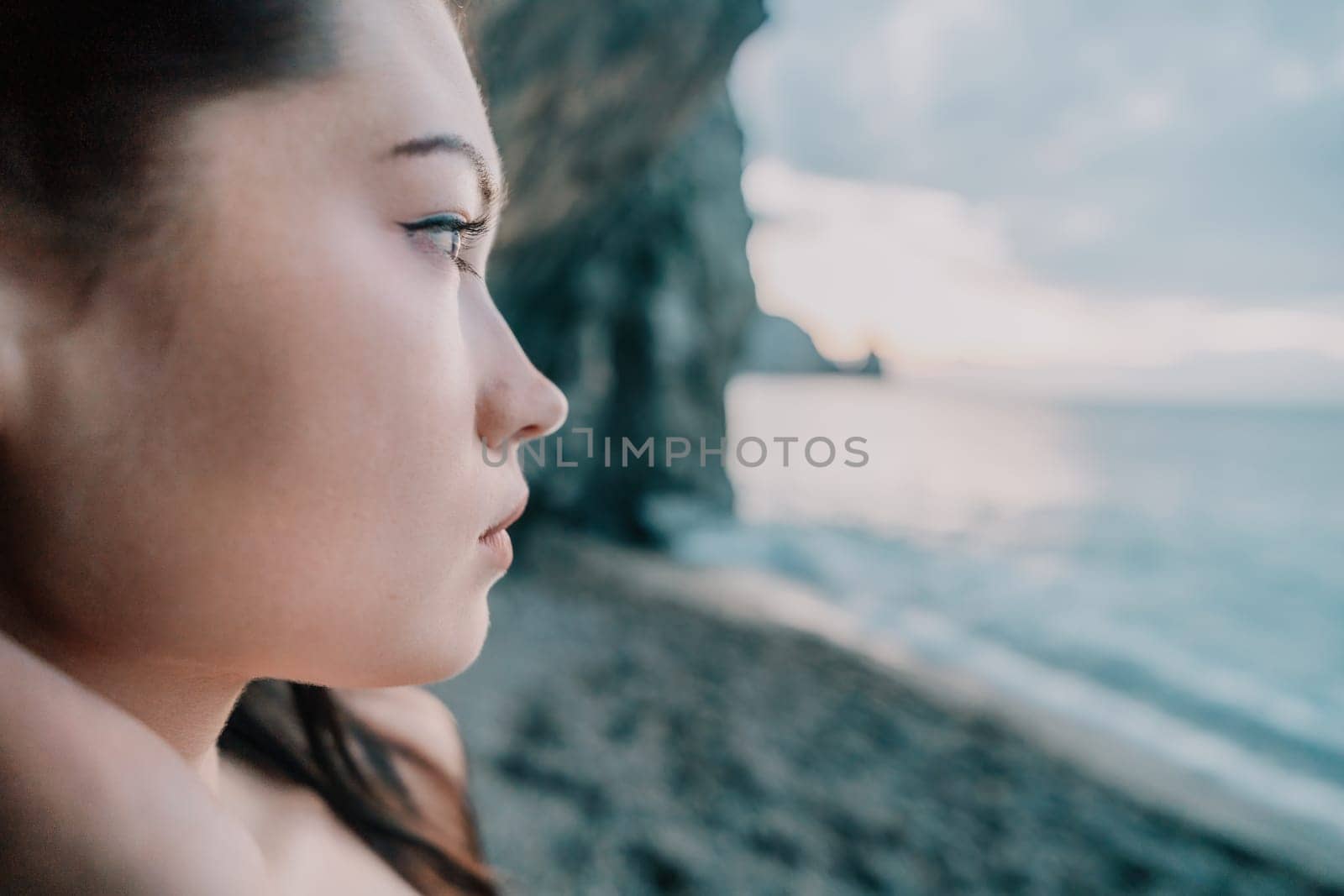 Portrait of cheerful female climber ascending a rock. The athlete girl trains in nature. Woman overcomes difficult climbing route.