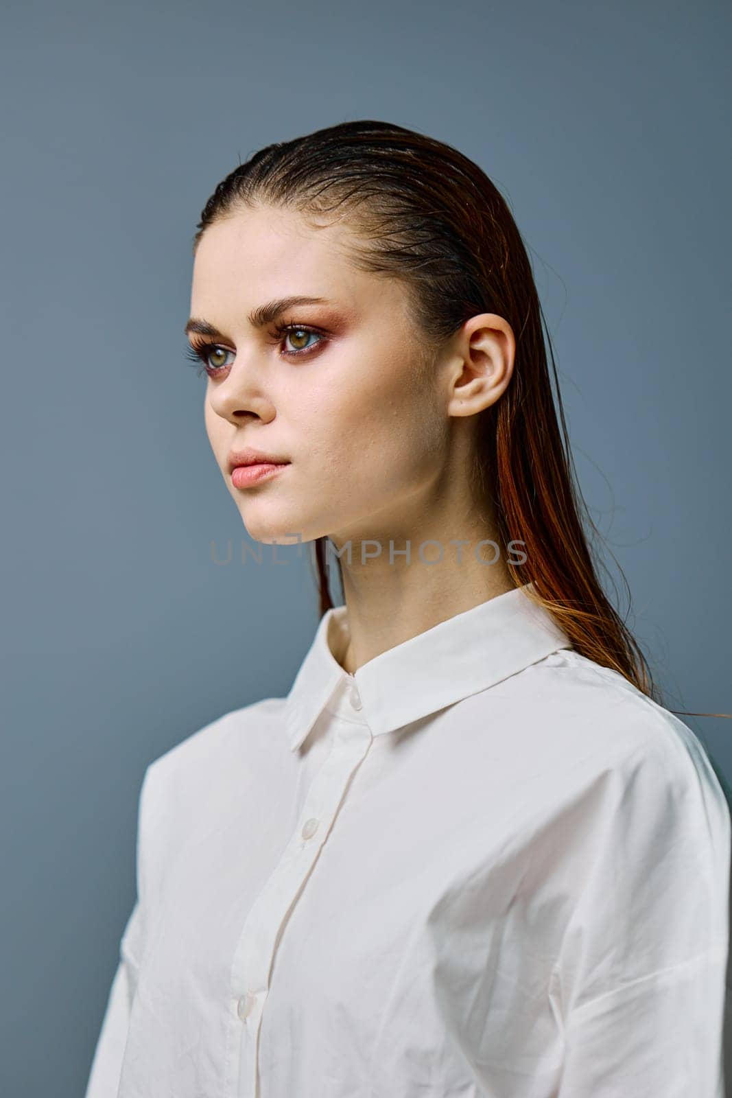 a close vertical portrait of a beautiful woman with neat evening makeup, and problematic skin, standing looking to the side. A photo from the fashion world without retouching. High quality photo