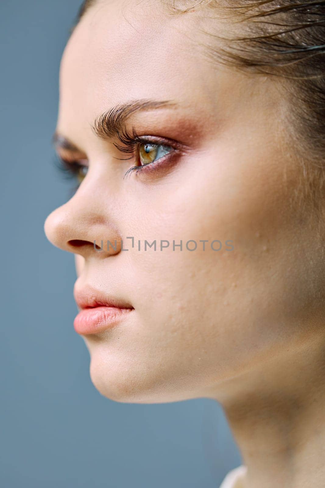 a close vertical portrait of a beautiful woman with neat evening makeup, and problematic skin, standing looking to the side. A photo from the fashion world without retouching by Vichizh