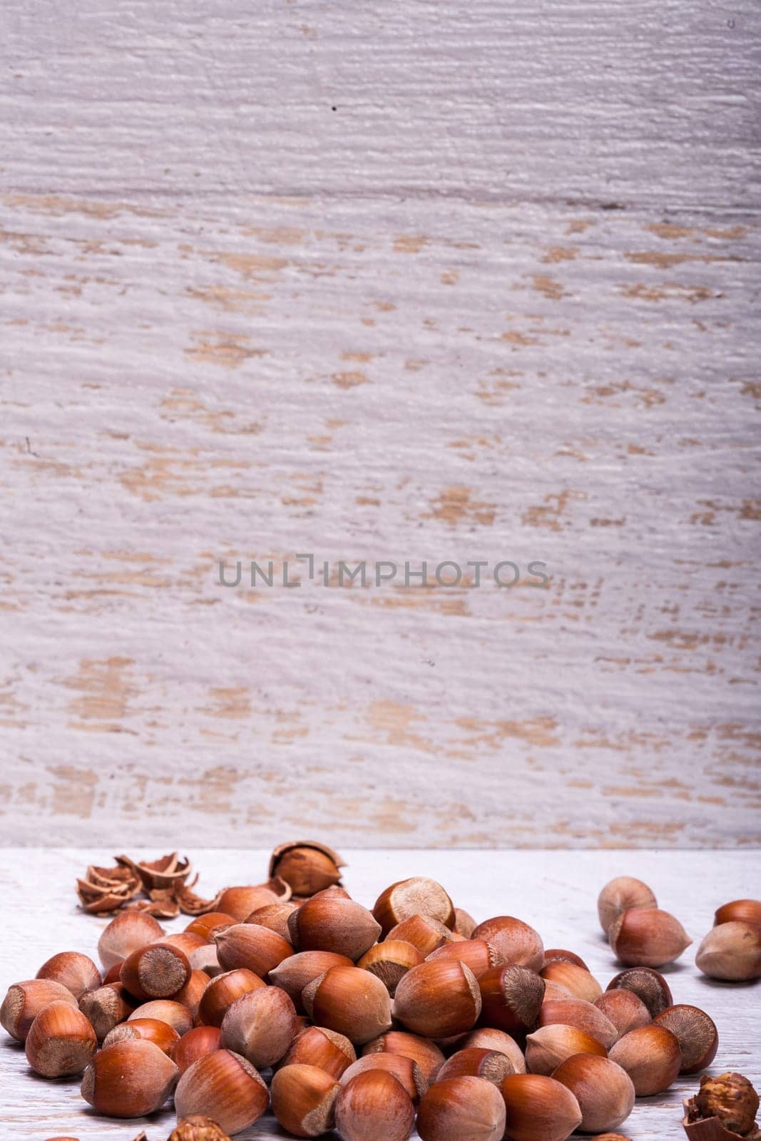 Healthy Hazelnuts on white wooden background by DCStudio