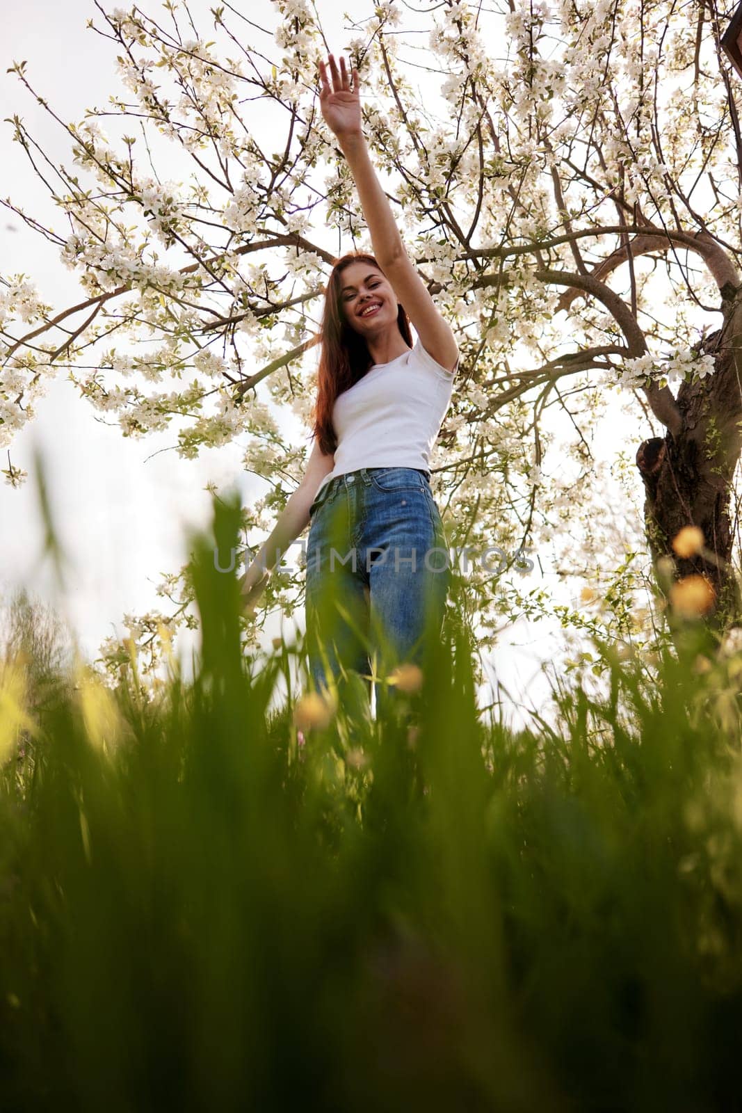 cute woman in light clothes posing next to a flowering tree in the countryside by Vichizh