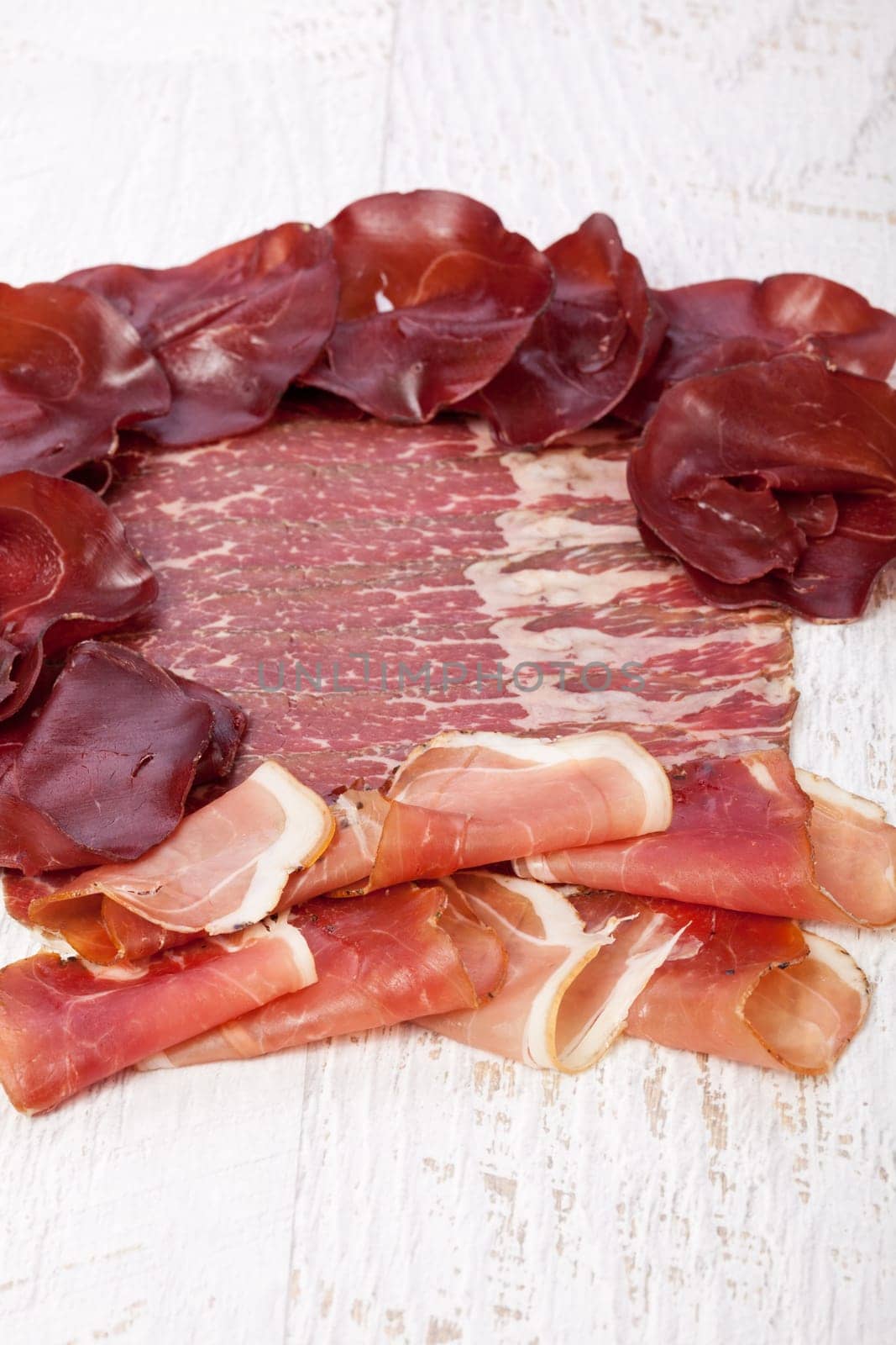 Delicious italian ham on wooden background by DCStudio