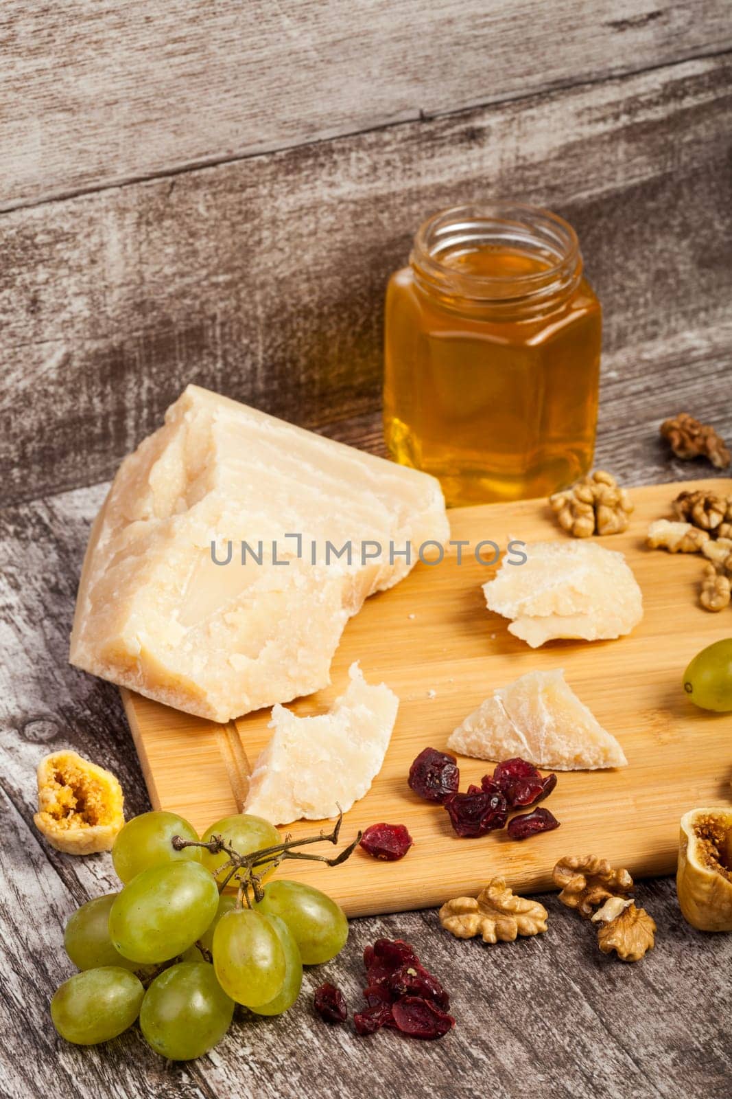 Honey, nuts, fruits and cheese on wooden background by DCStudio
