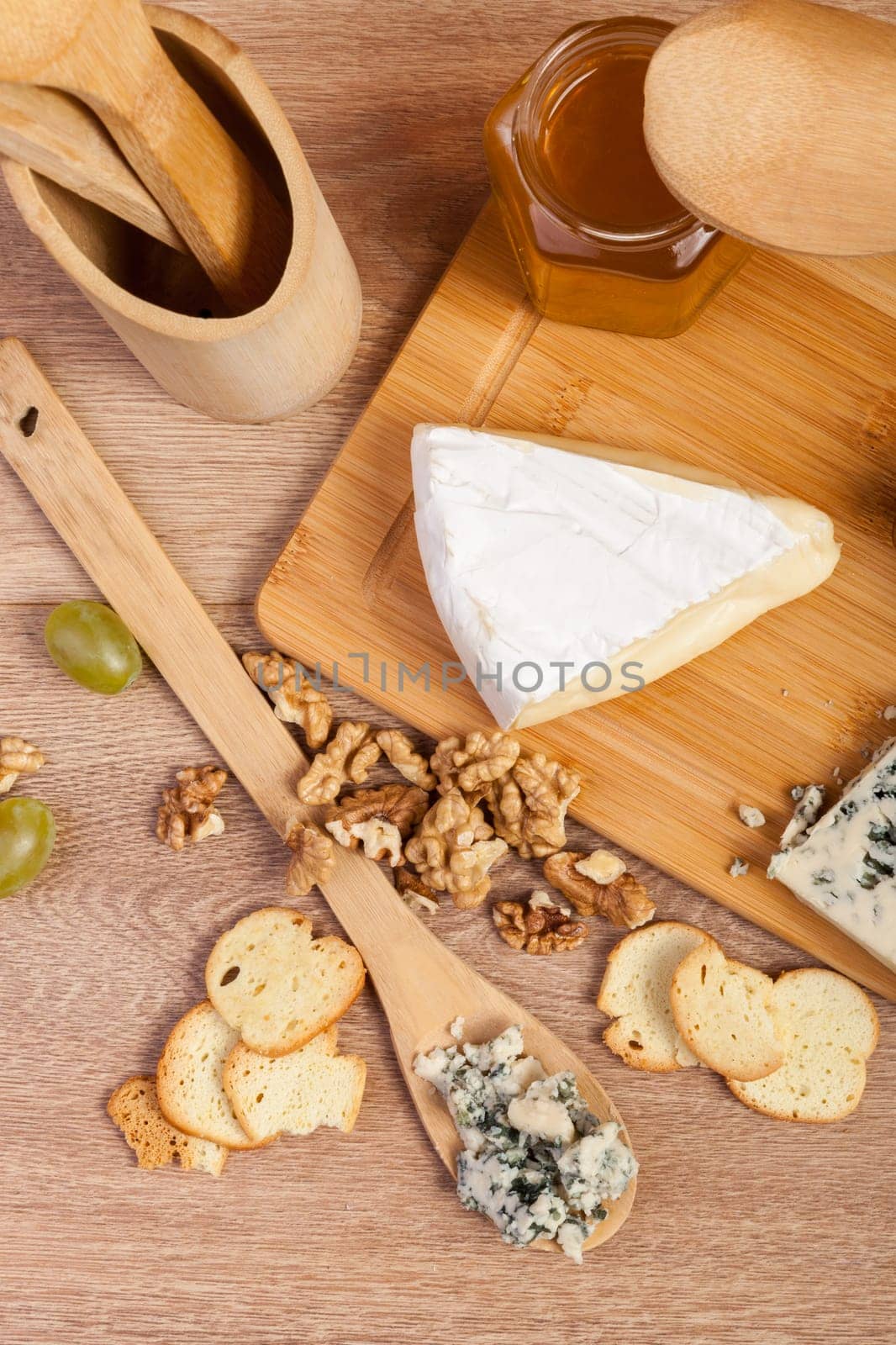 Cheese, nuts and honey on wooden background by DCStudio