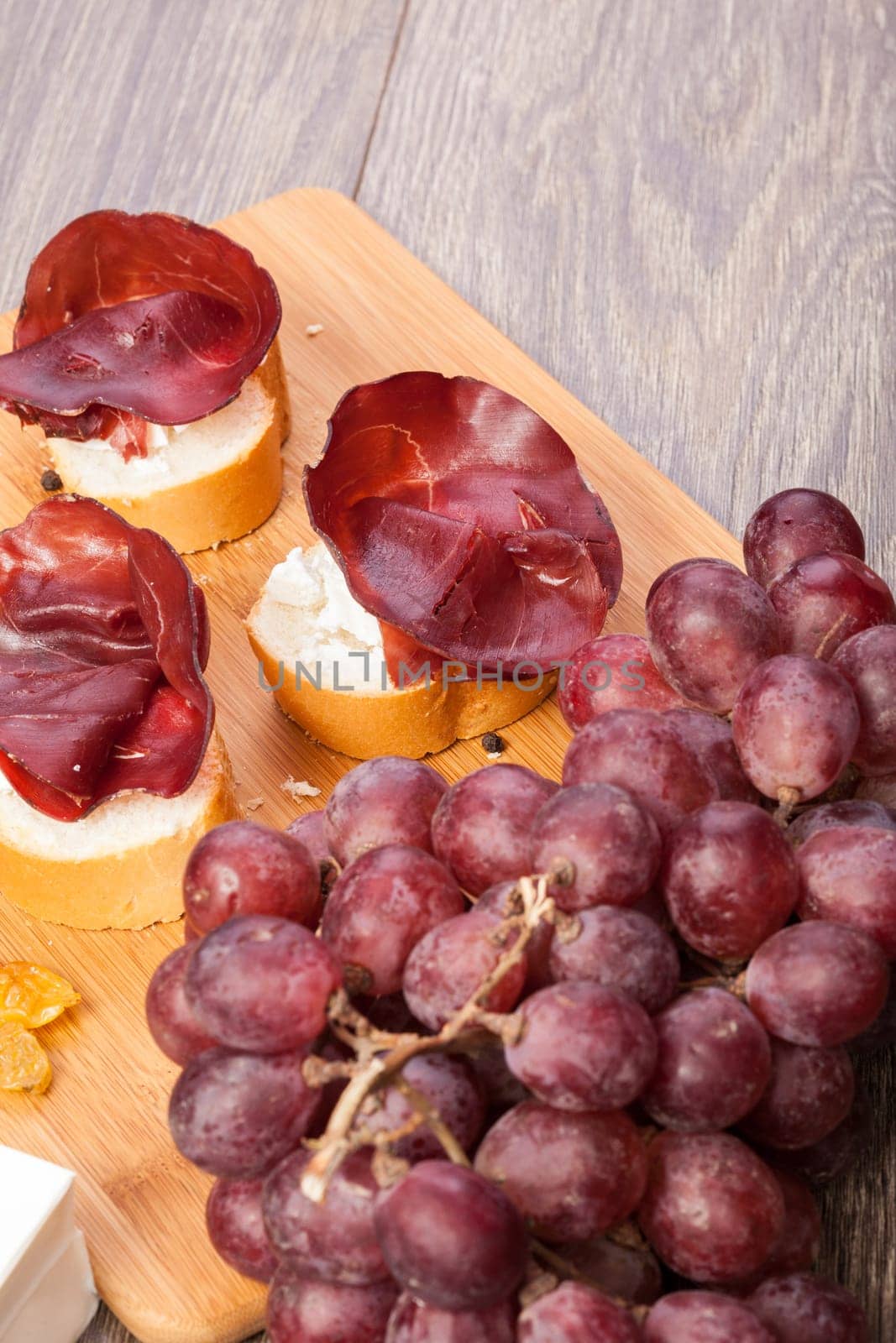 Close up of Mixed antipasto from grape, crackers and ham by DCStudio