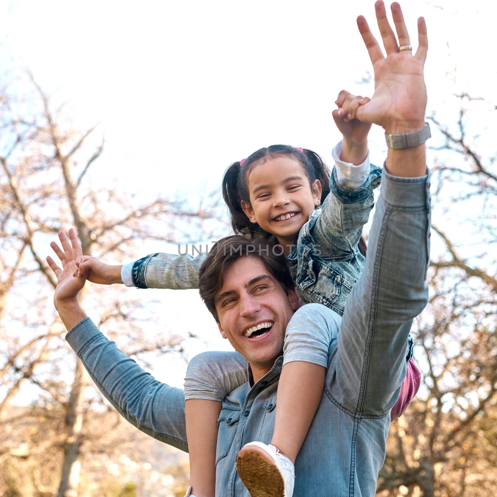 Daddy loves you this much. an adorable little girl having fun with her father at the park