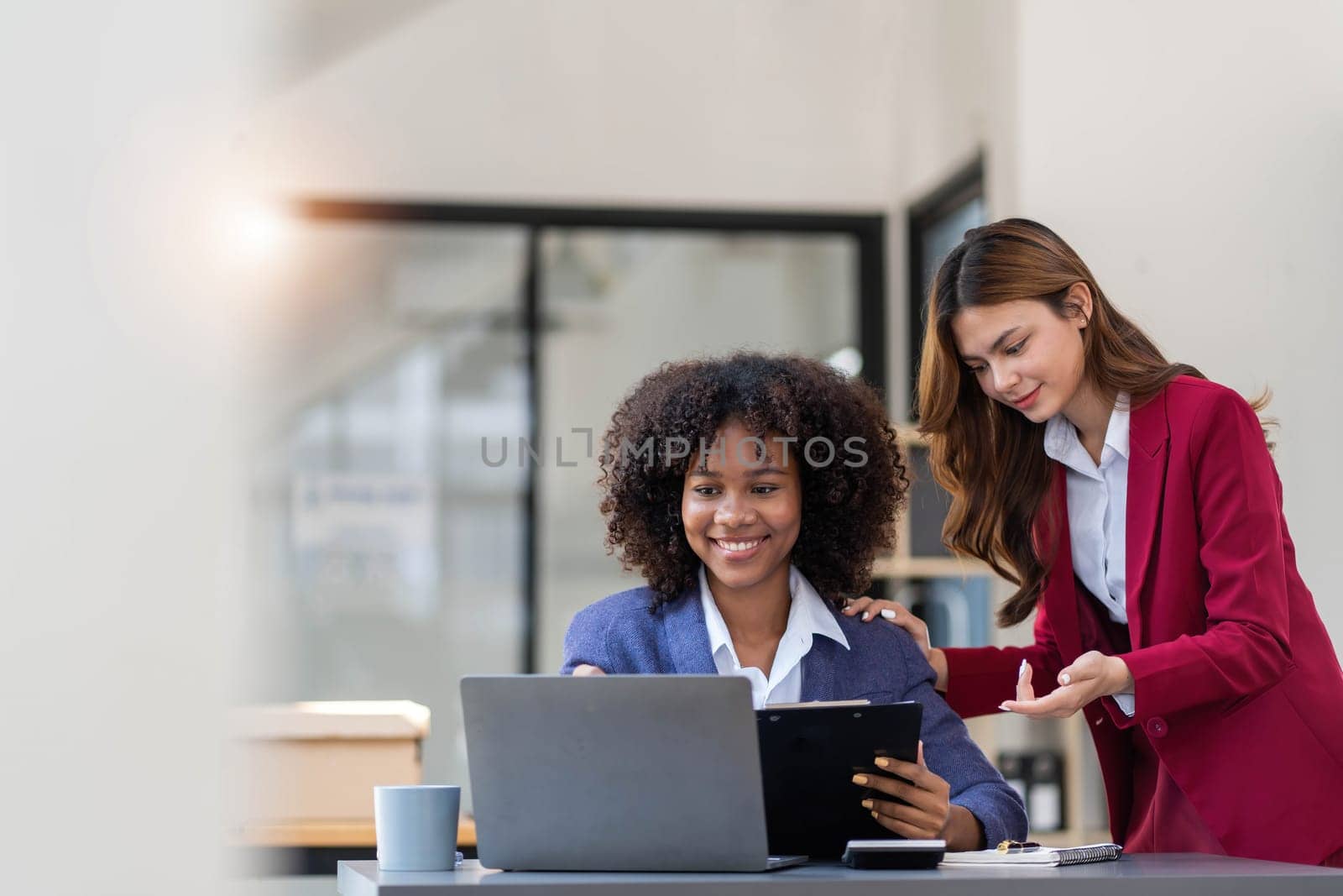 Two business people talk project strategy at office meeting room. Businessman discuss project planning with colleague at modern workplace while having conversation and advice on financial data report...