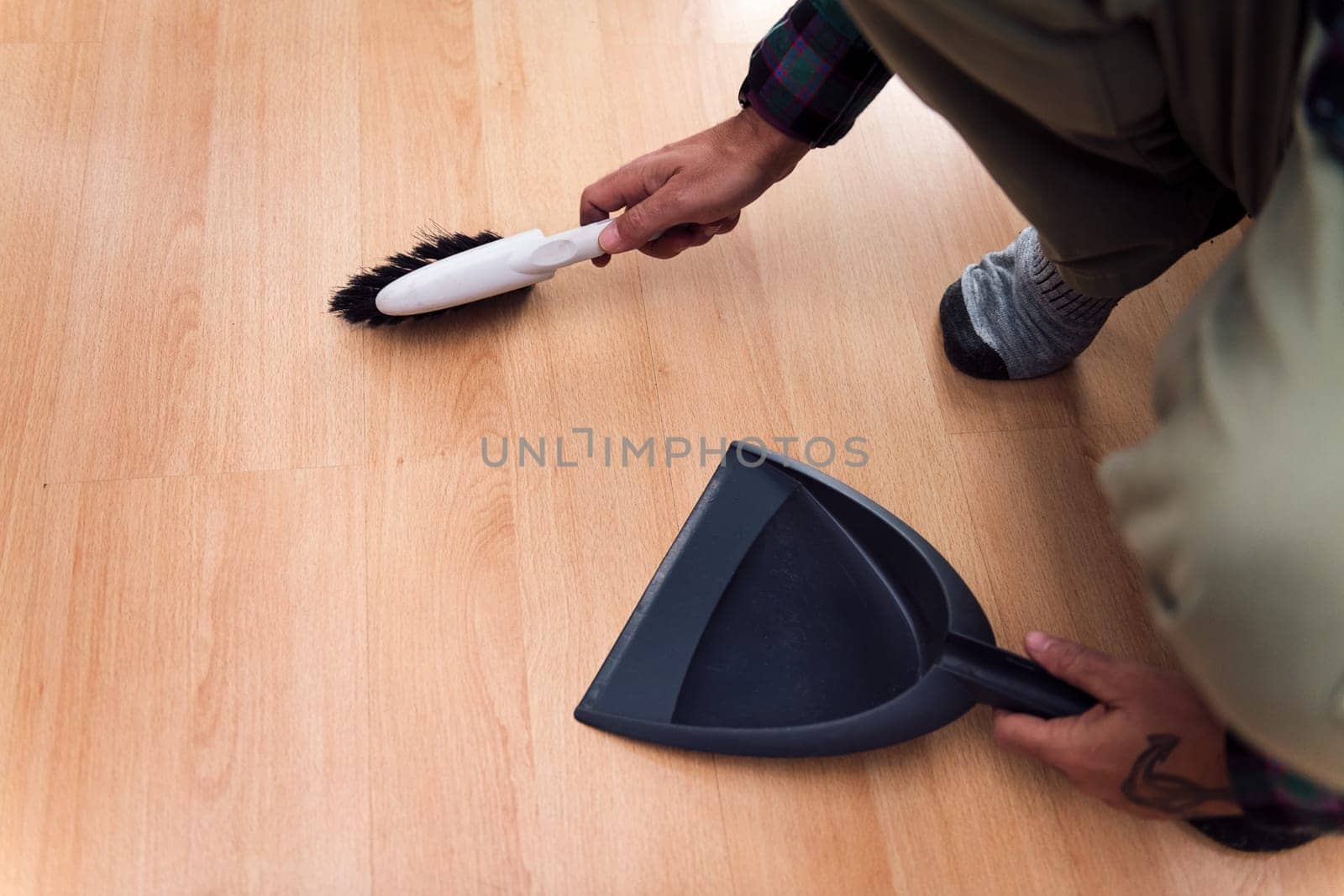 close up of a person sweeping the floor with a brush and dustpan, home cleaning concept, copy space for text
