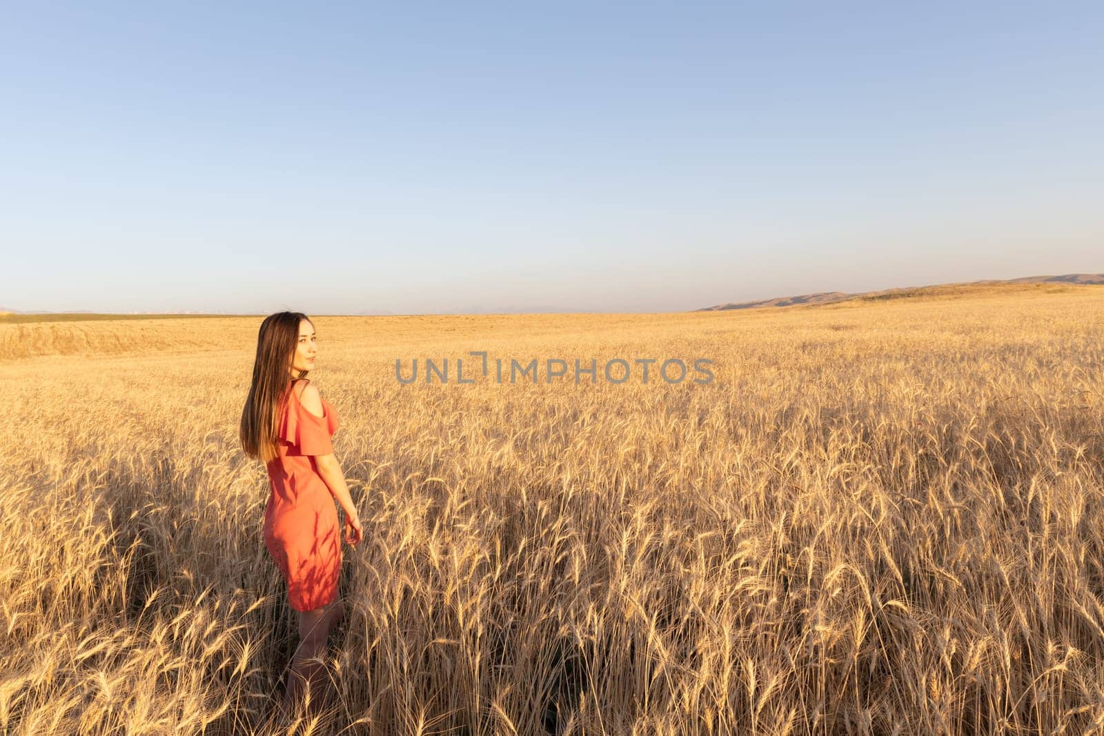 Young woman in the wheat field, mental and physical wellbeing concept. Copy space.