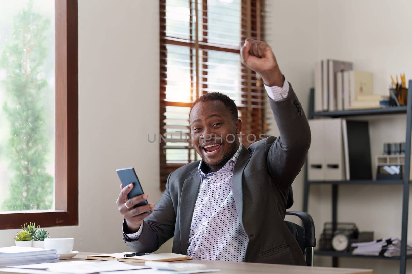 American African black man happy while reading email have a good news in smartphone. business finance and technology concept by itchaznong