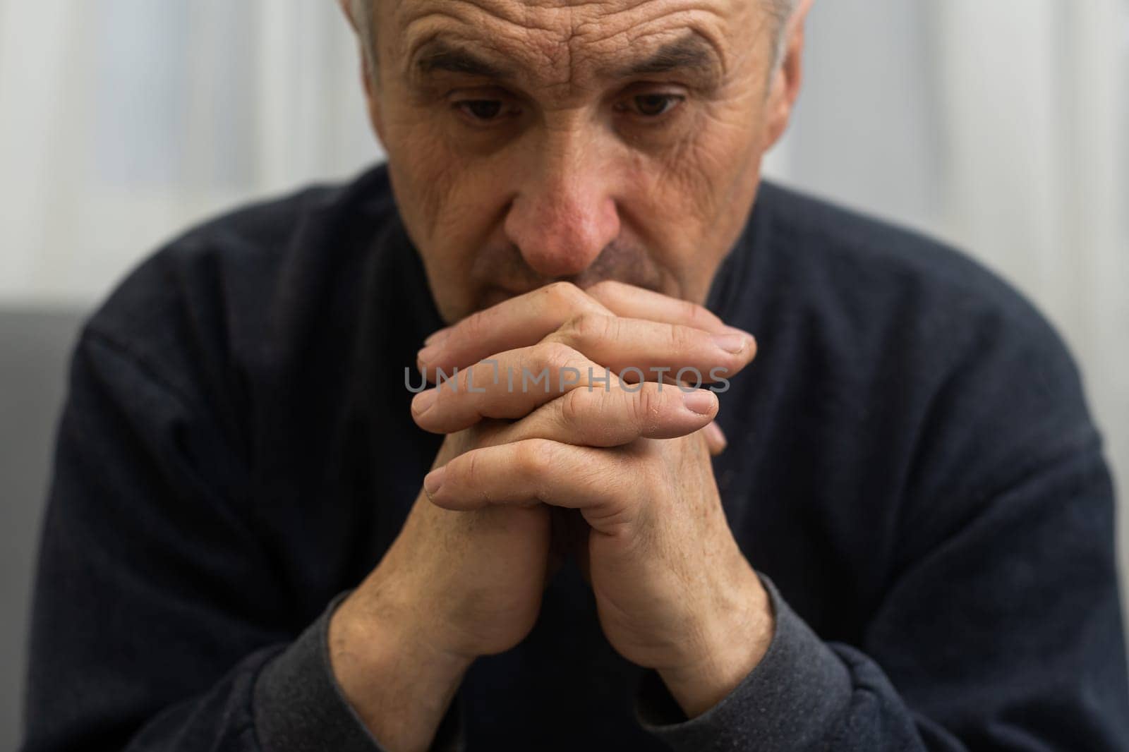 Elderly caucasian man with interlocked fingers by Andelov13