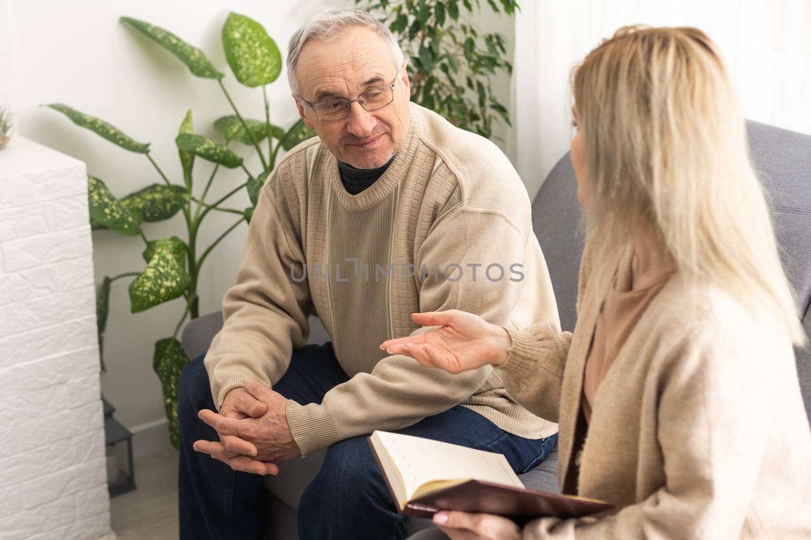 Close up anxious serious old man listening to female doctor at meeting in hospital, therapist physician consulting mature patient about disease, treatment, elderly generation healthcare concept.