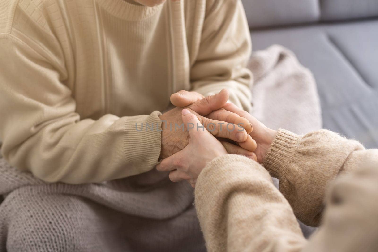 Young woman holding senior man hands, closeup.