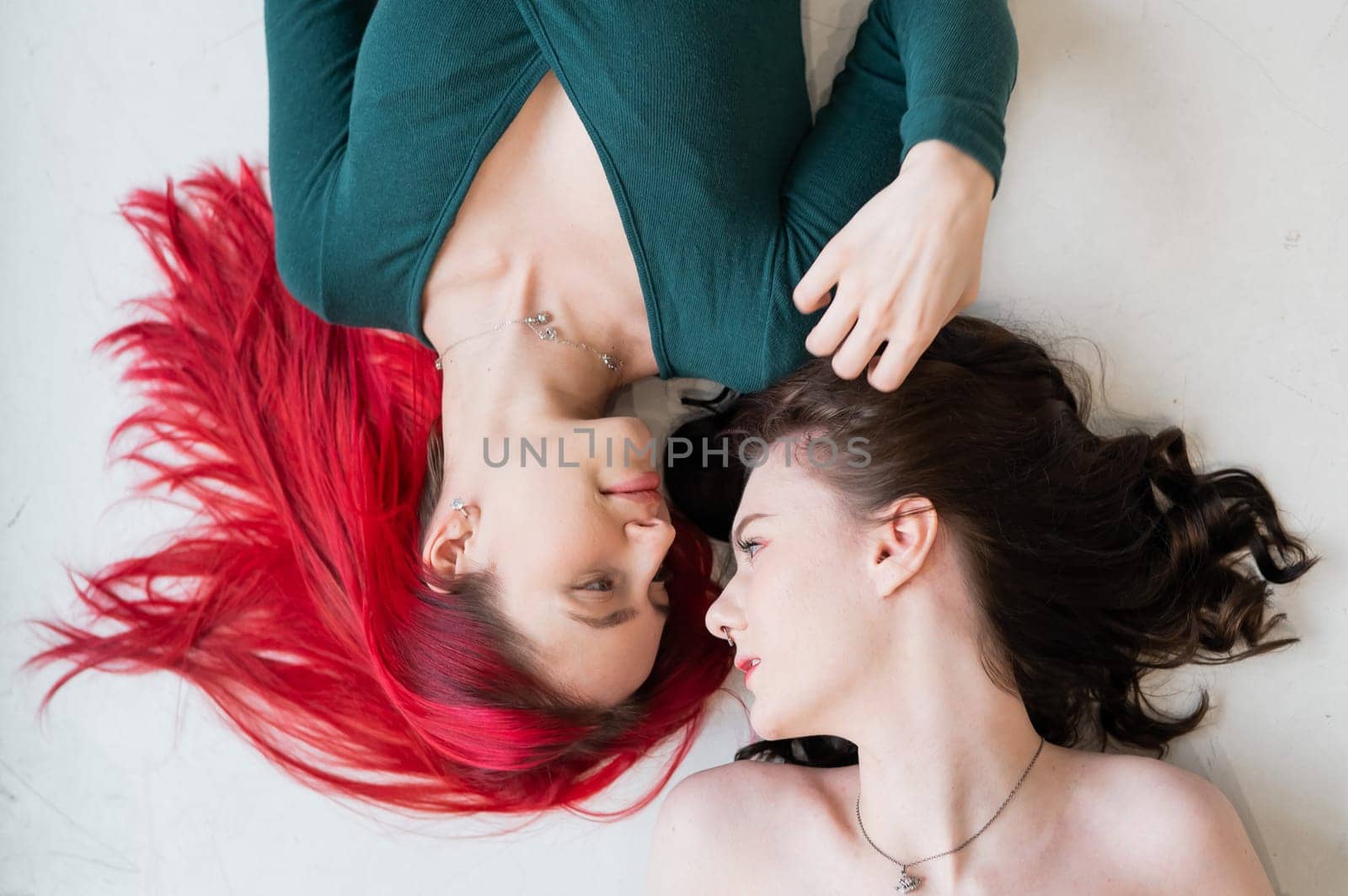 Top view of caucasian women lying and kissing