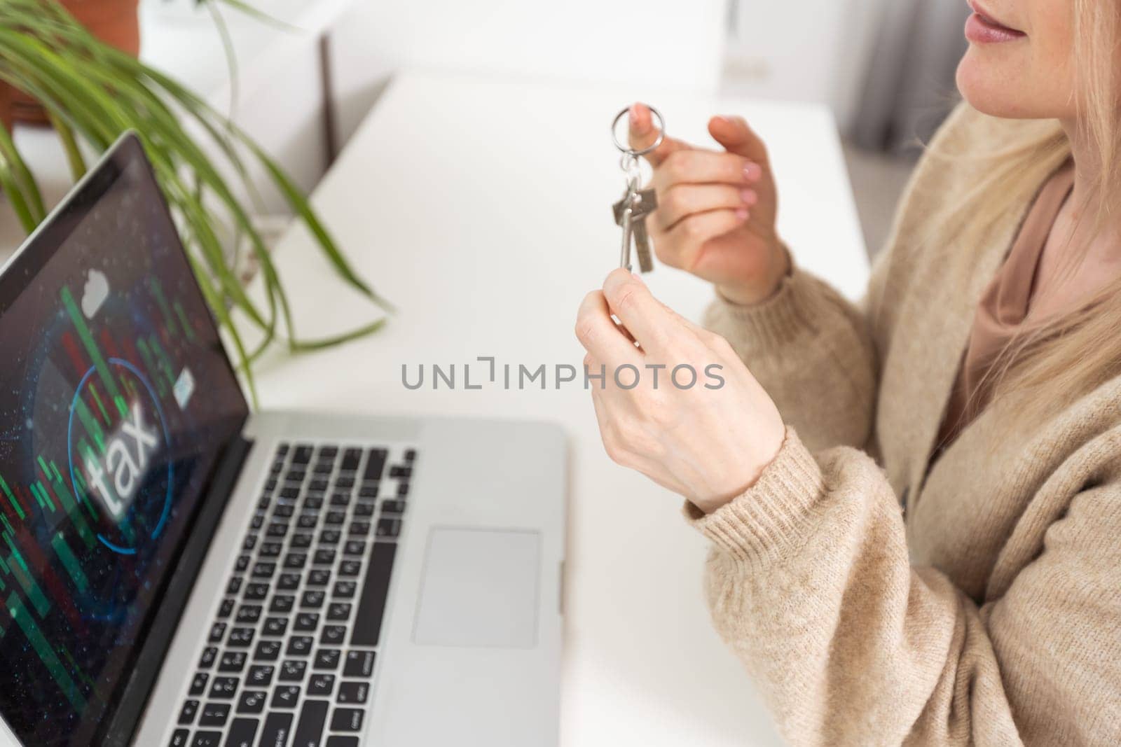 woman holding key with laptop and taxes by Andelov13