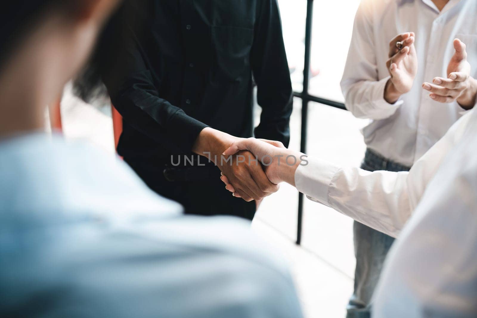 Business partnership meeting concept. Image businesspeople handshake. Successful businesspeople handshaking after good deal. Group support concept by nateemee