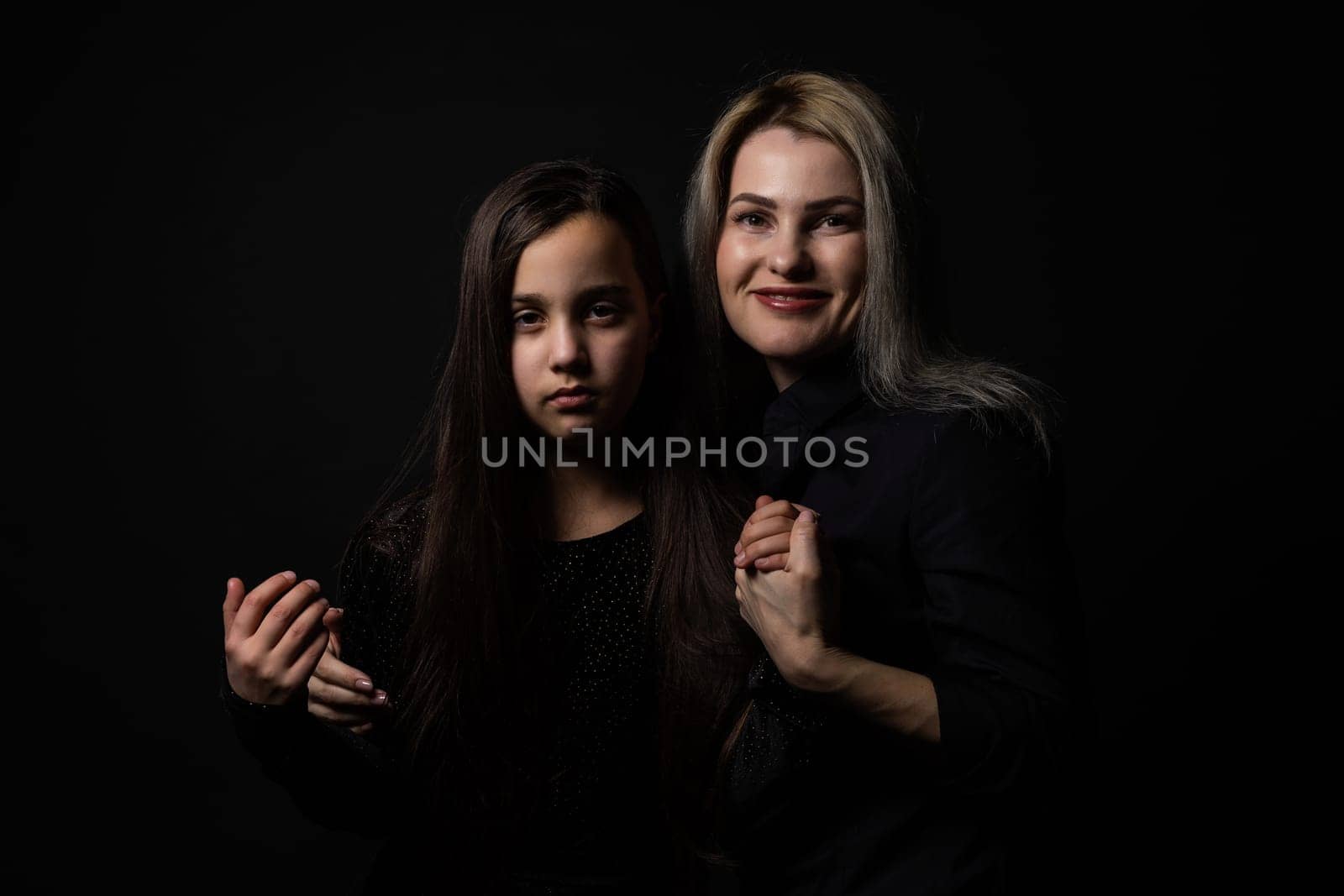 a little girl with her mother is praying while hugging.