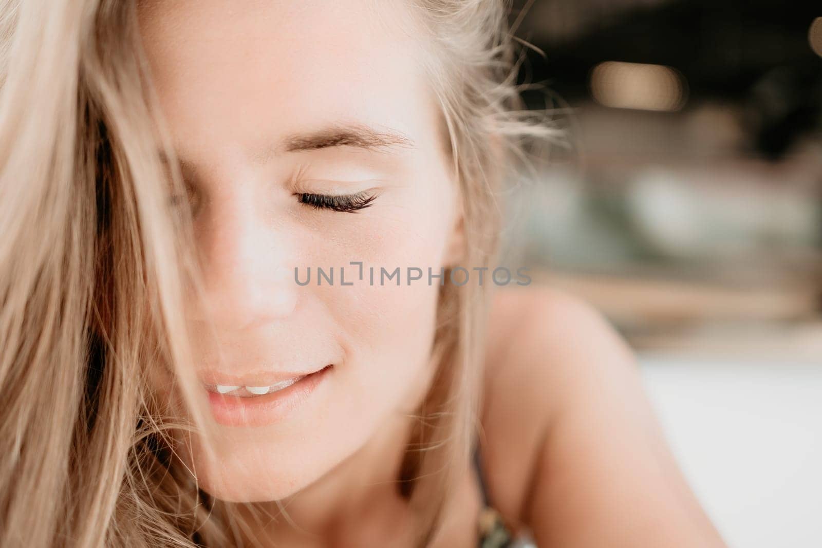 Happy woman portrait in cafe. Boho chic fashion style. Outdoor photo of young happy woman with long hair, sunny weather outdoors sitting in modern cafe