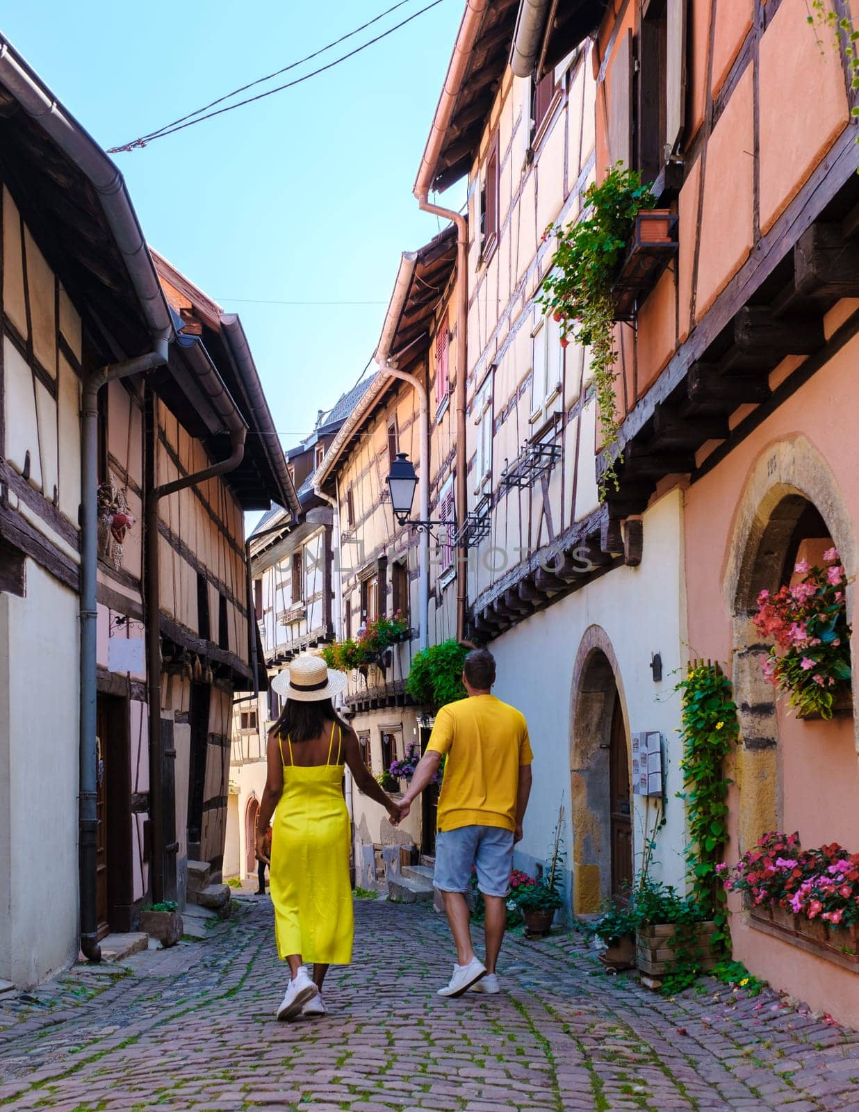 A couple of men and women on vacation in Eguisheim France Beautiful view of the colorful romantic city of Eguisheim near Colmar during summer