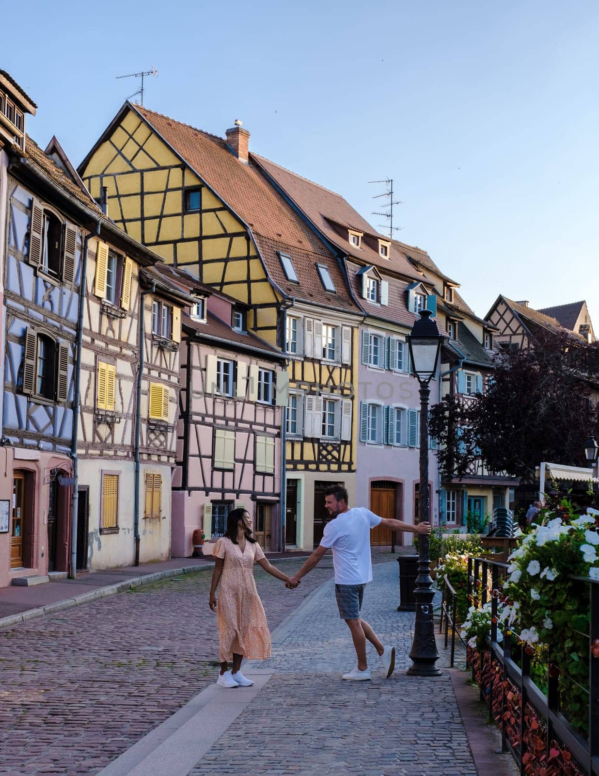 A couple of men and women on vacation at the romantic city Colmar, France, Alsace during summer, the Historic town of Colmar, Alsace region, France with beautiful canals called Le Petit Venice