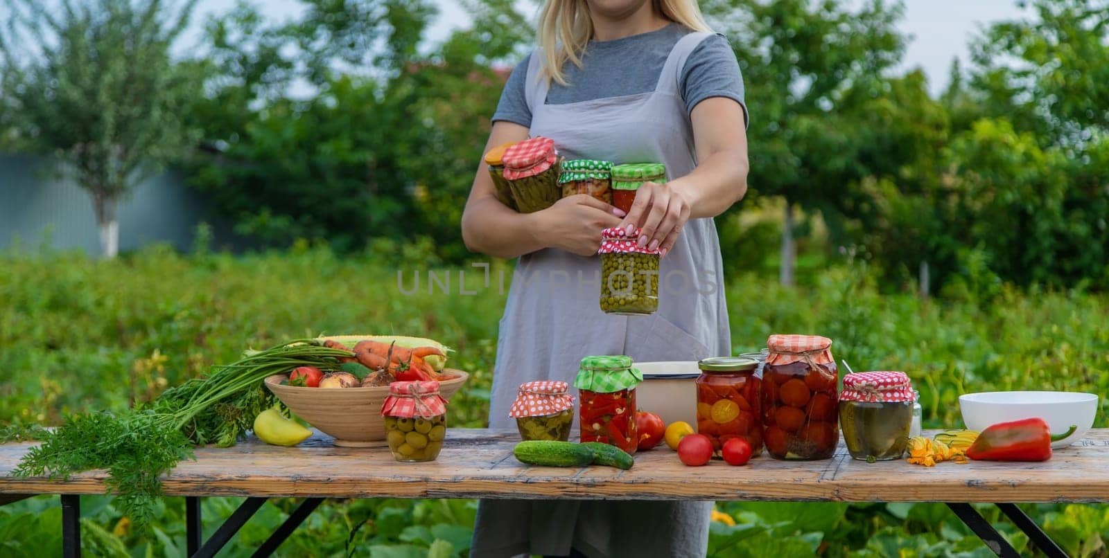 A woman preserves vegetables in jars. Selective focus. Food.