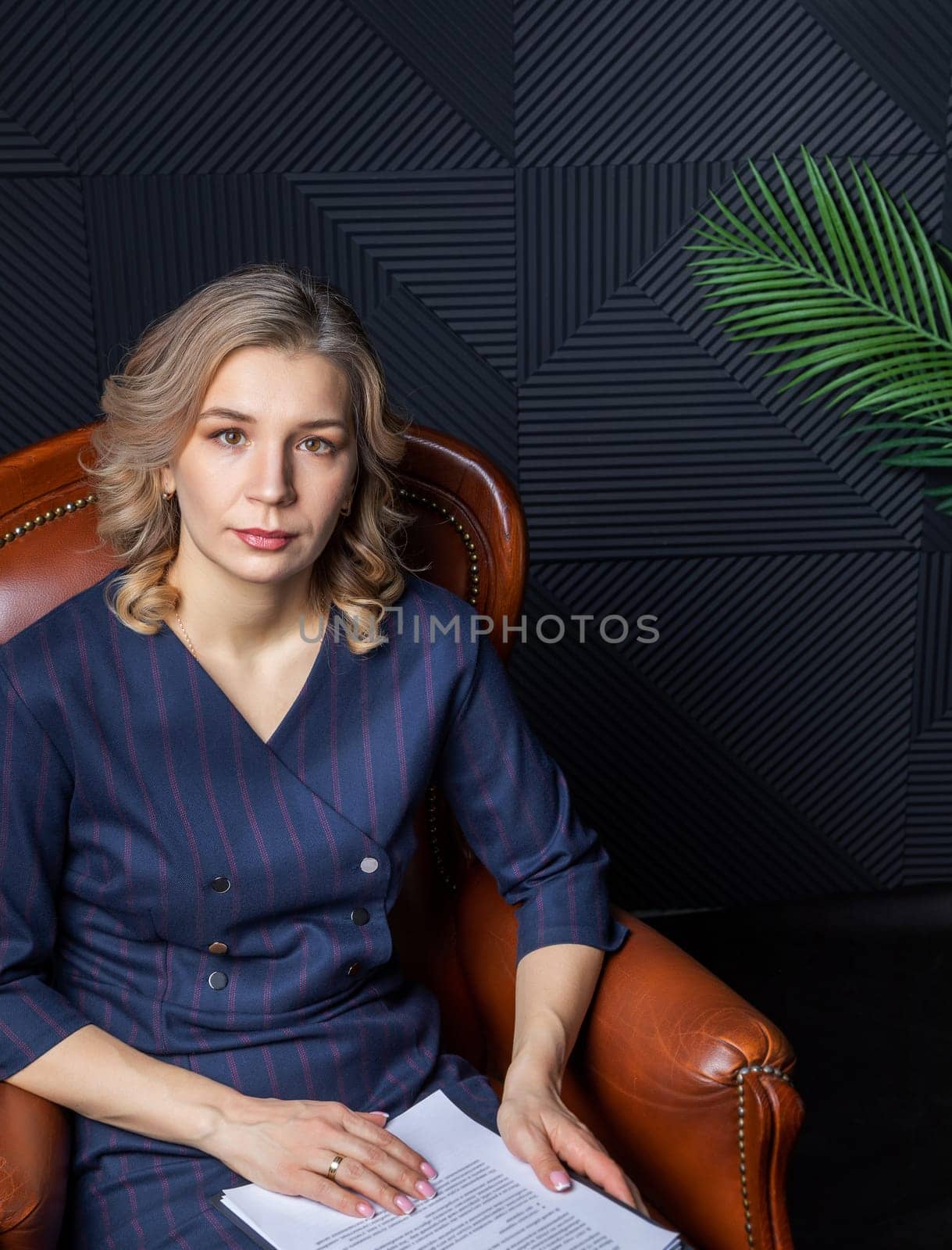 Portrait of a successful female psychologist in her office, notebook in hand