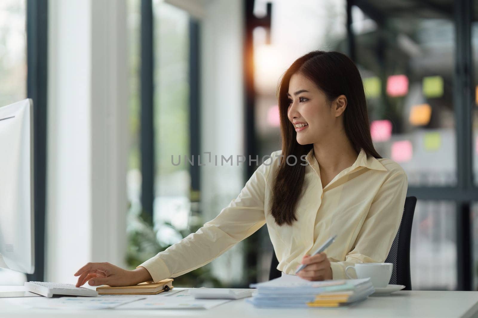 Beautiful Asian Banker or Accountant makes financial report and tax, analyzes profits. Accountant checks status of financial.