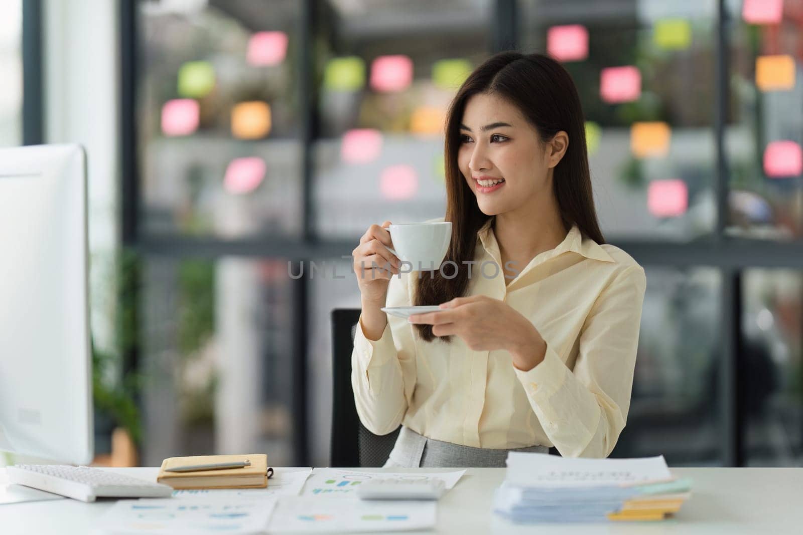 Beautiful Asian Banker or Accountant makes financial report and tax, analyzes profits. Accountant checks status of financial.