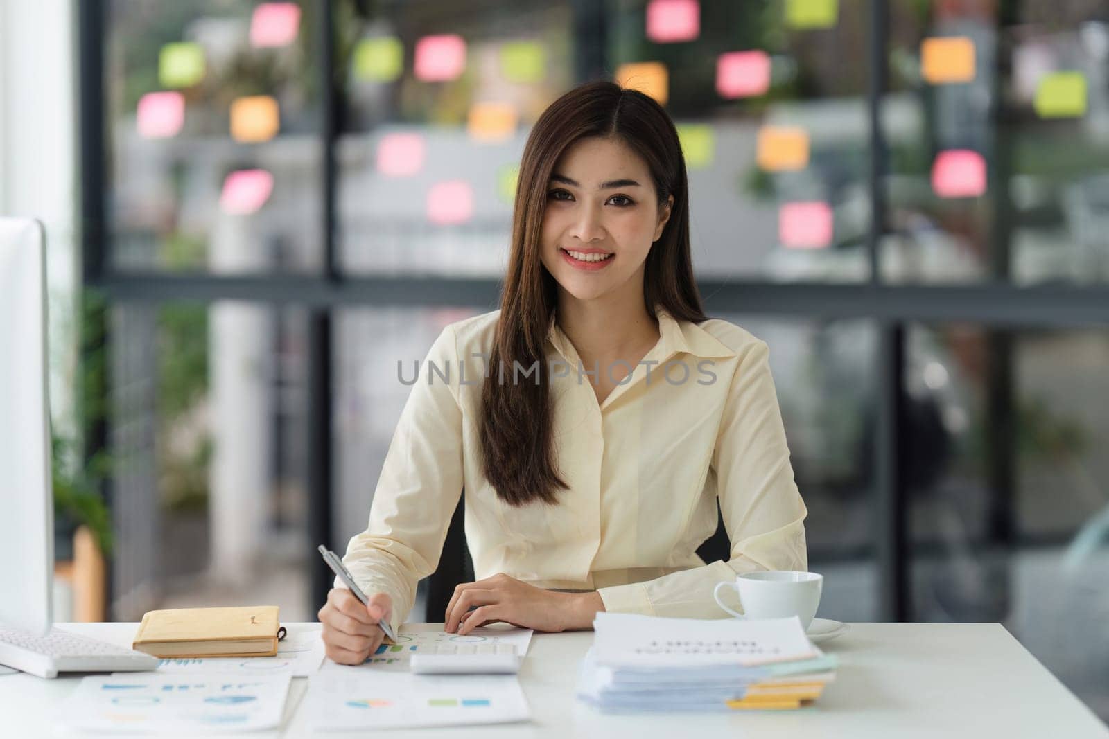 Beautiful Asian Banker or Accountant makes financial report and tax, analyzes profits. Accountant checks status of financial by itchaznong