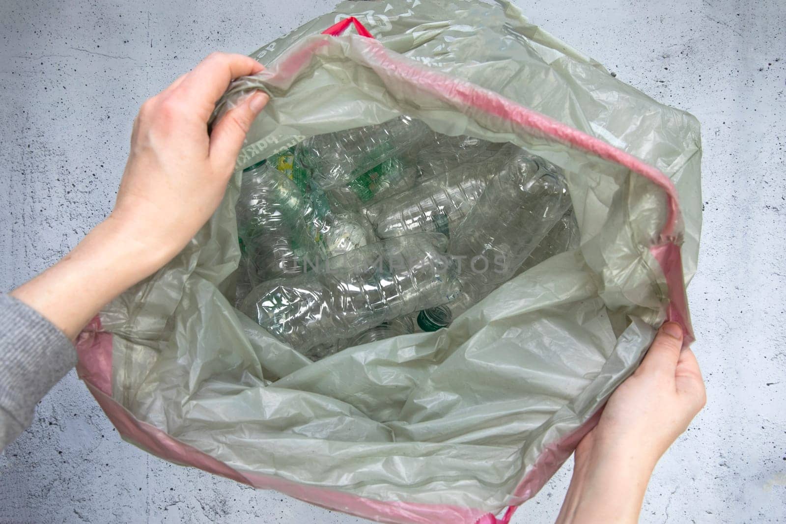 Hand getting plastic bottles to dispose in garbage bag ready to recycle, waste management and plastic recycle. Sorting waste plastic bottles top view 4k