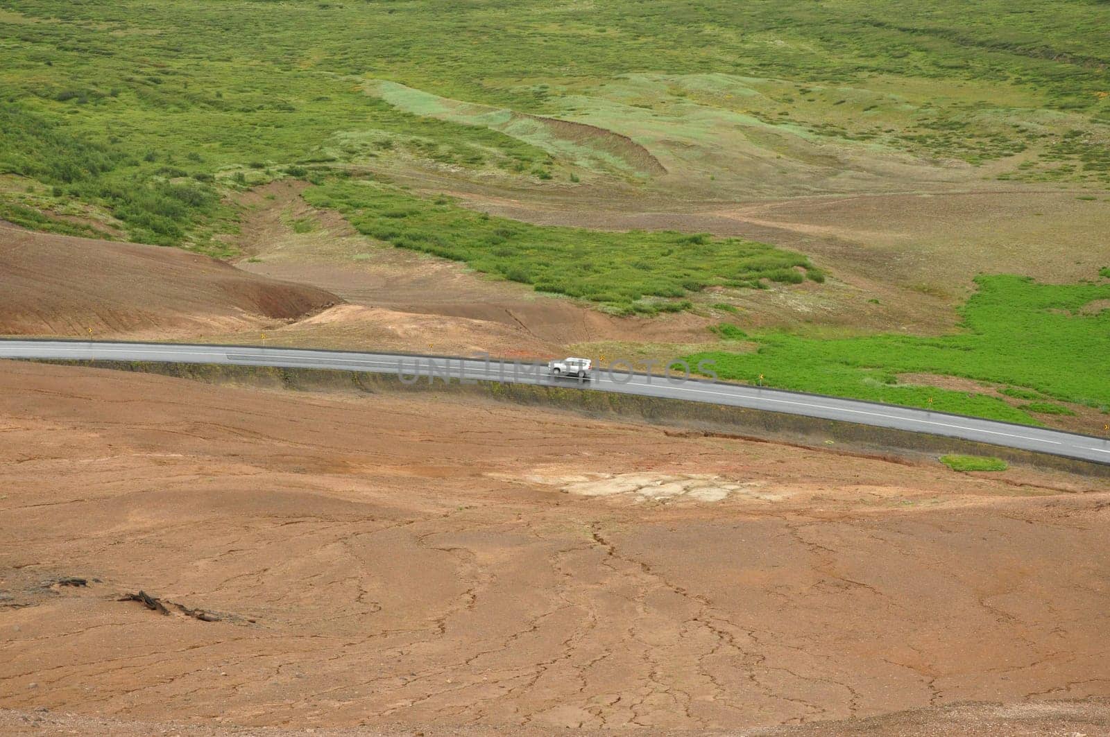 Aerial view of a car on a lonely road in a valley near the high-temperature area in Hverir, Iceland