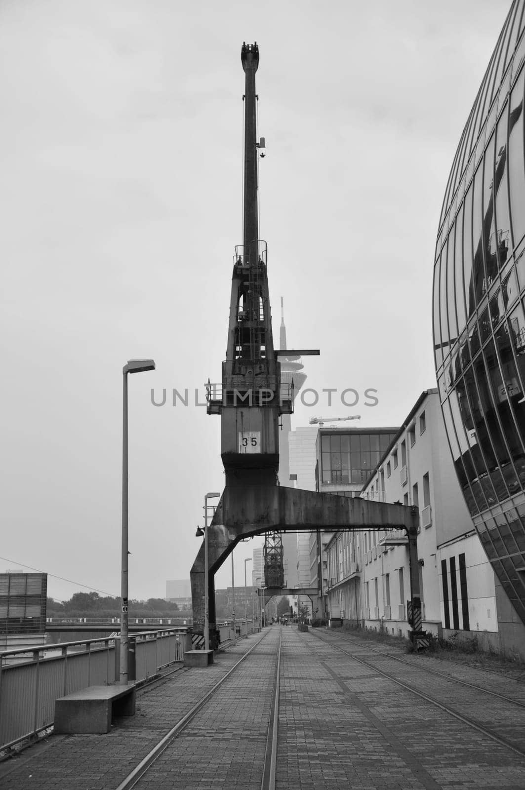 Vertical grayscale shot of an old cargo crane in the Media Harbor in Dusseldorf, Germany.