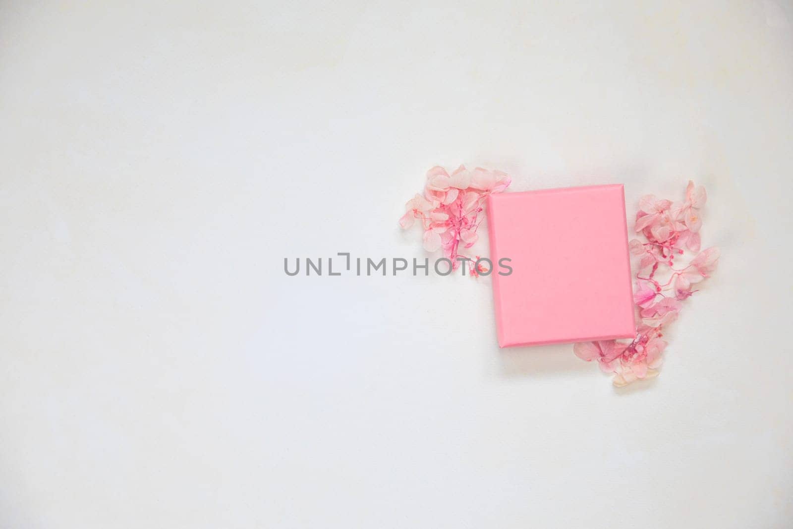 Open and closed pink gift box place for product on bright background with flowers .Flat lay, top view, mock-up gift,present Mothers Day,Valentines Day, Birthday concept copy space